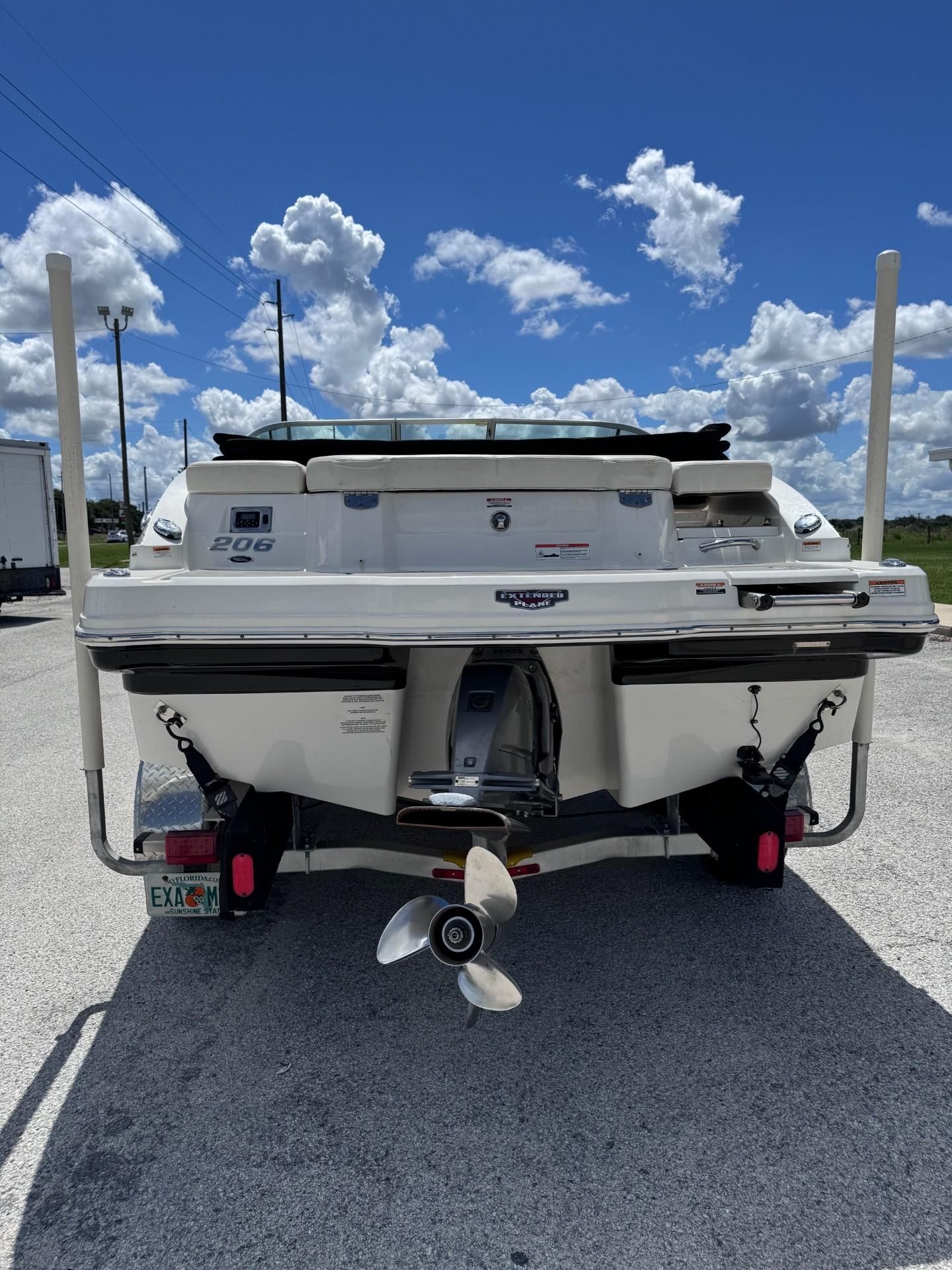The image shows the rear of a white Chaparral 206 SSi boat on a trailer.