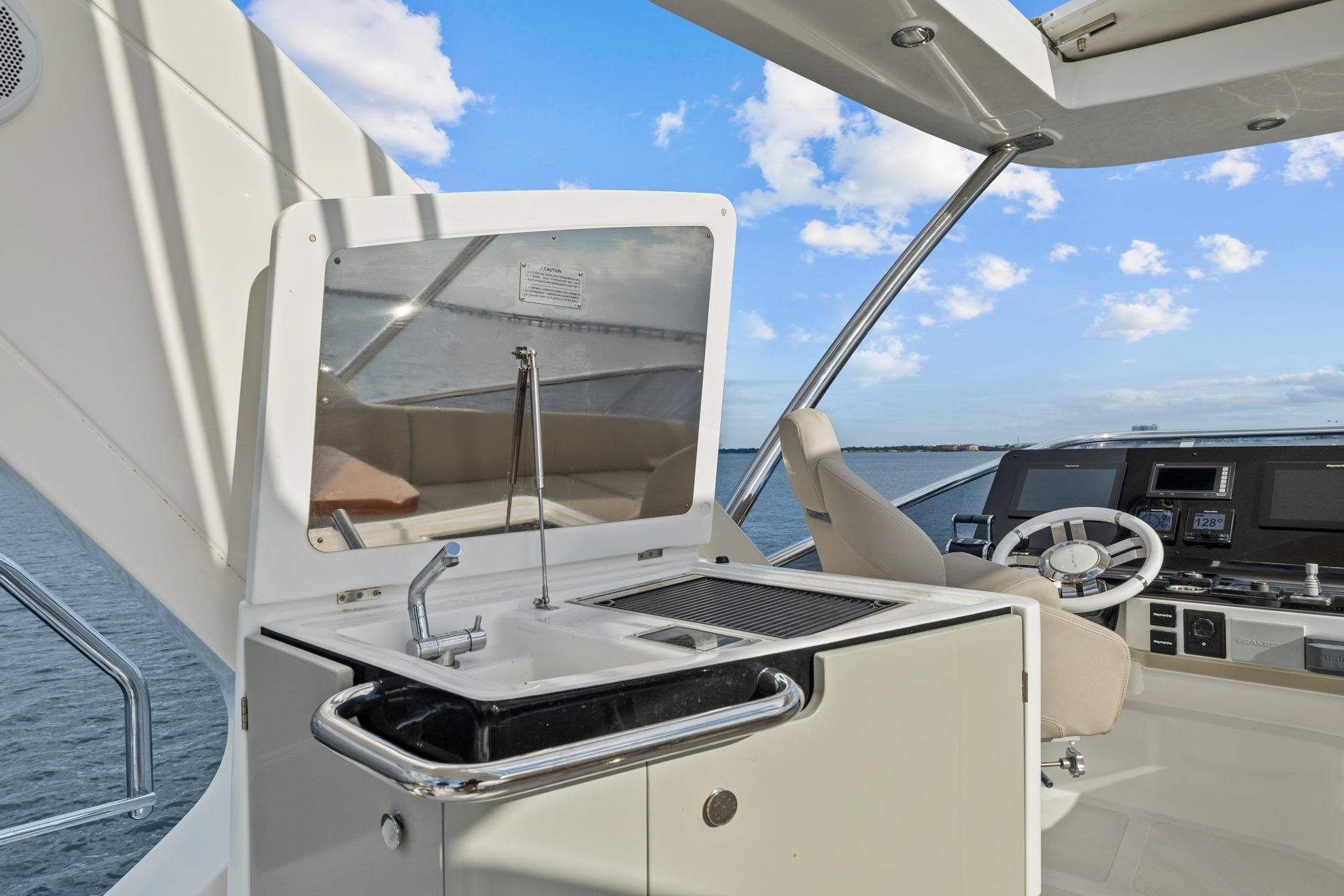 Luxury yacht Azimut 55 (2019) helm with sink and steering wheel, ocean view.