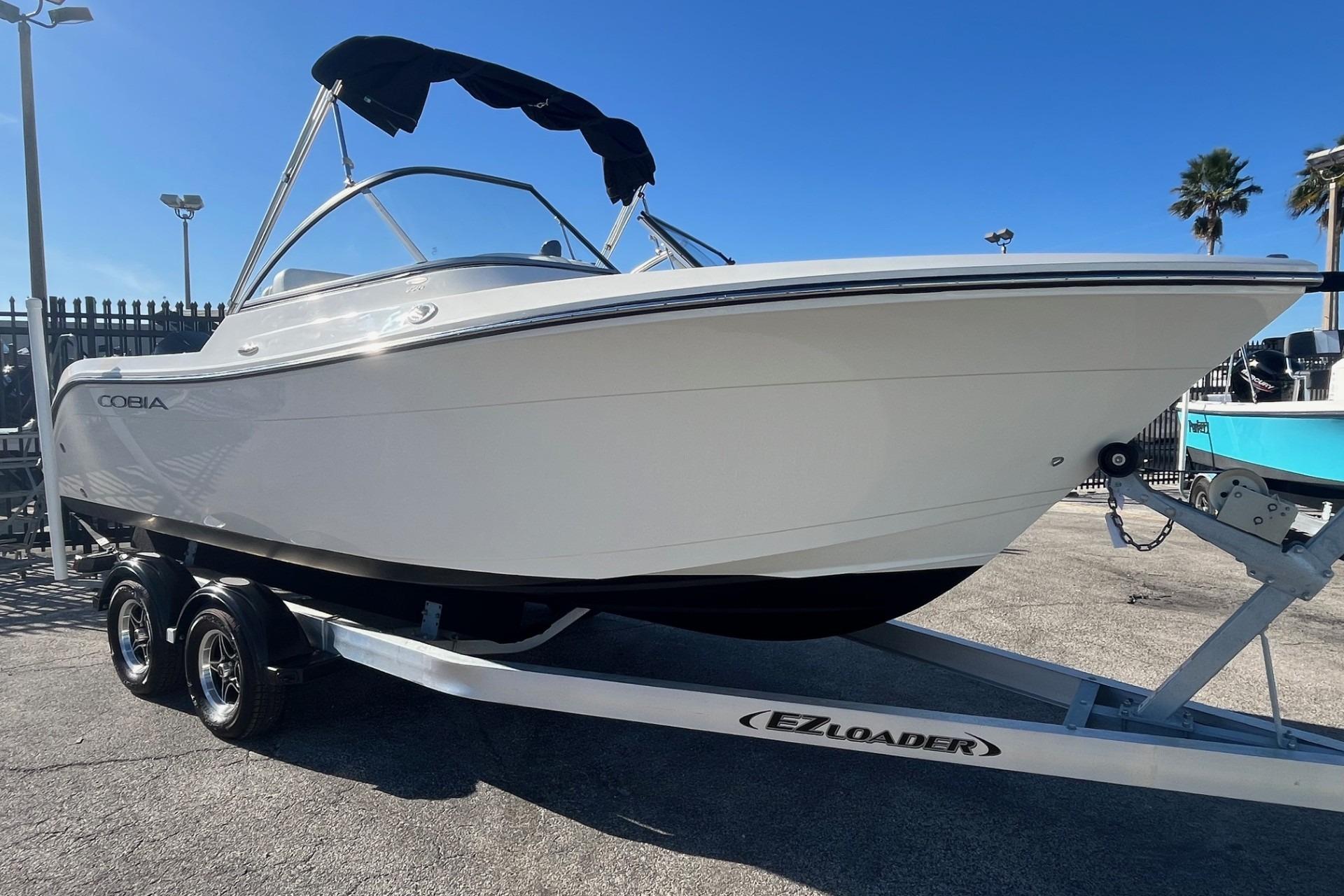2023 Cobia 220 Dual Console boat on EZ Loader trailer, parked outdoors.