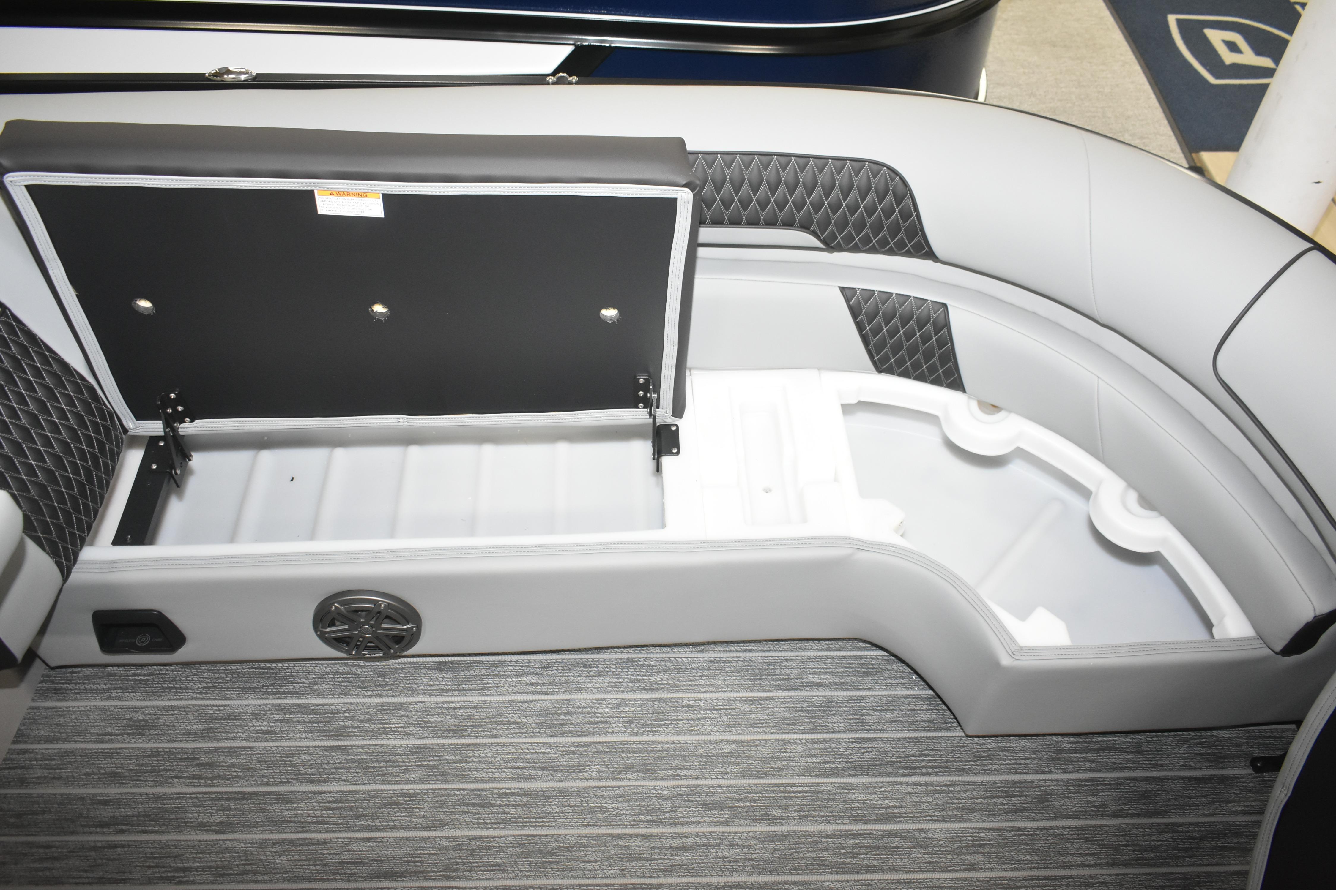 2026 Premier 250 Solaris Sport boat interior storage compartment with open lid and speaker.