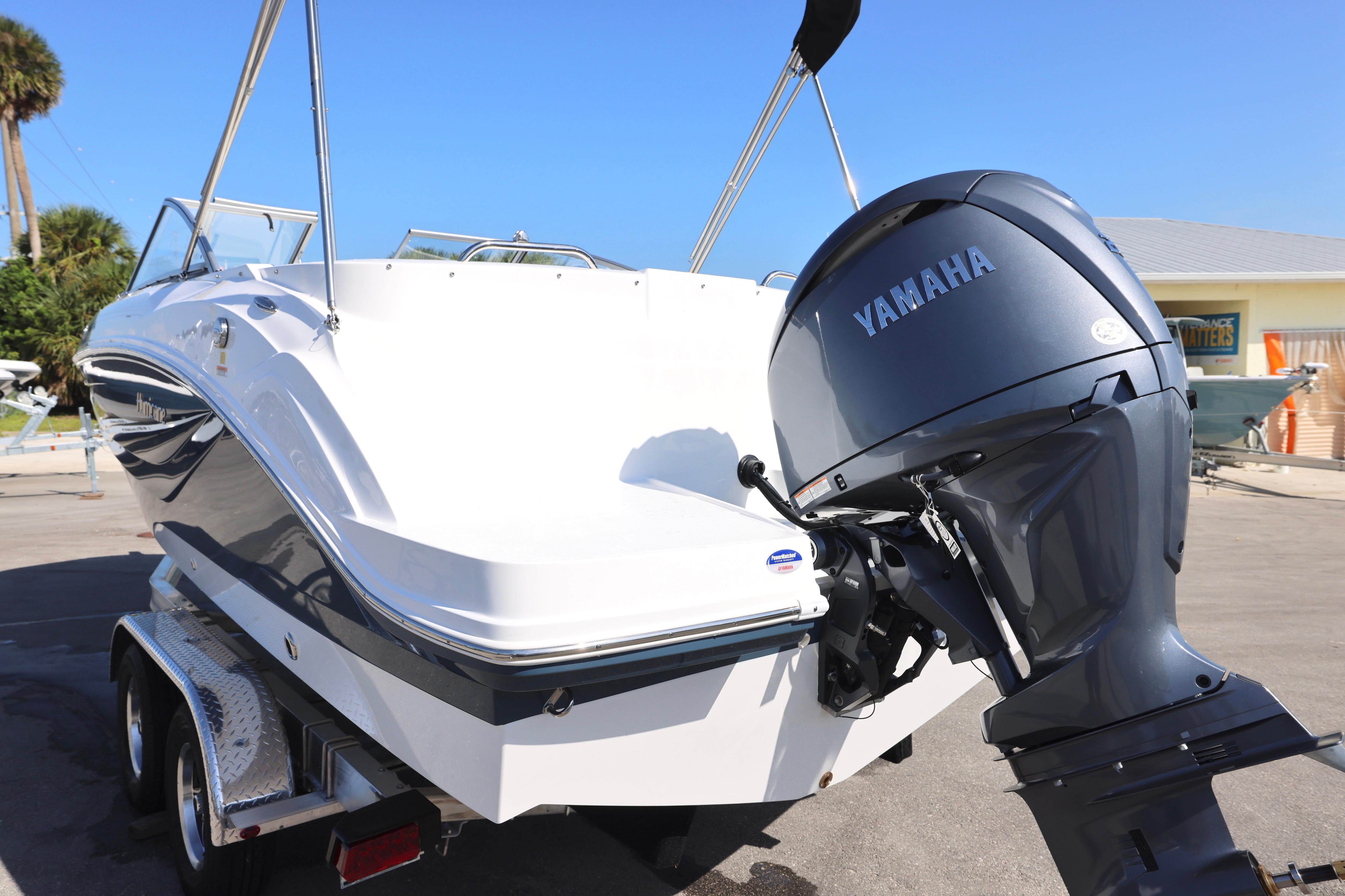 2026 Hurricane SunDeck 235 OB boat with Yamaha outboard motor on trailer.