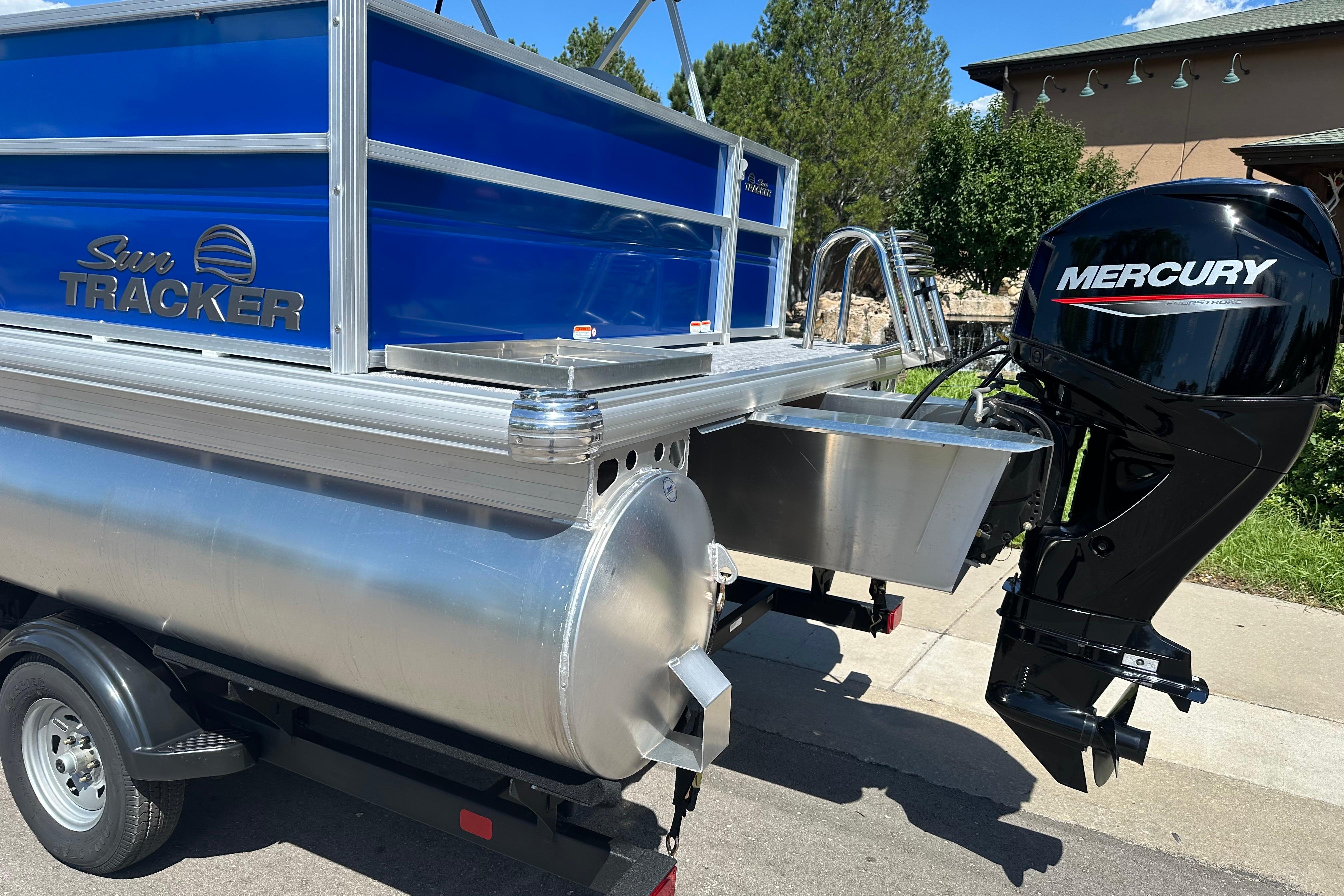 2026 Sun Tracker Party Barge 16 DLX with Mercury outboard motor, parked outdoors.