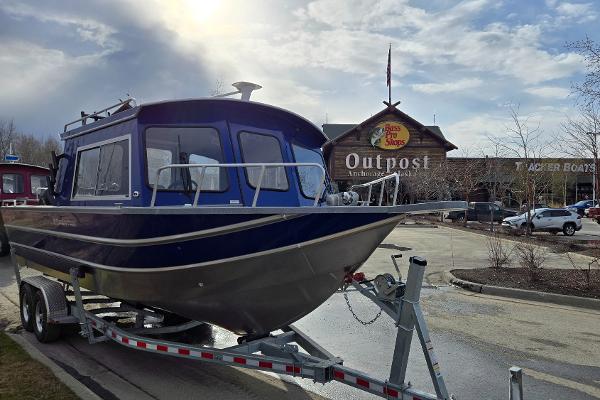 2024 Spartan 26 Maximus Pro XL boat on trailer outside Bass Pro Shops.