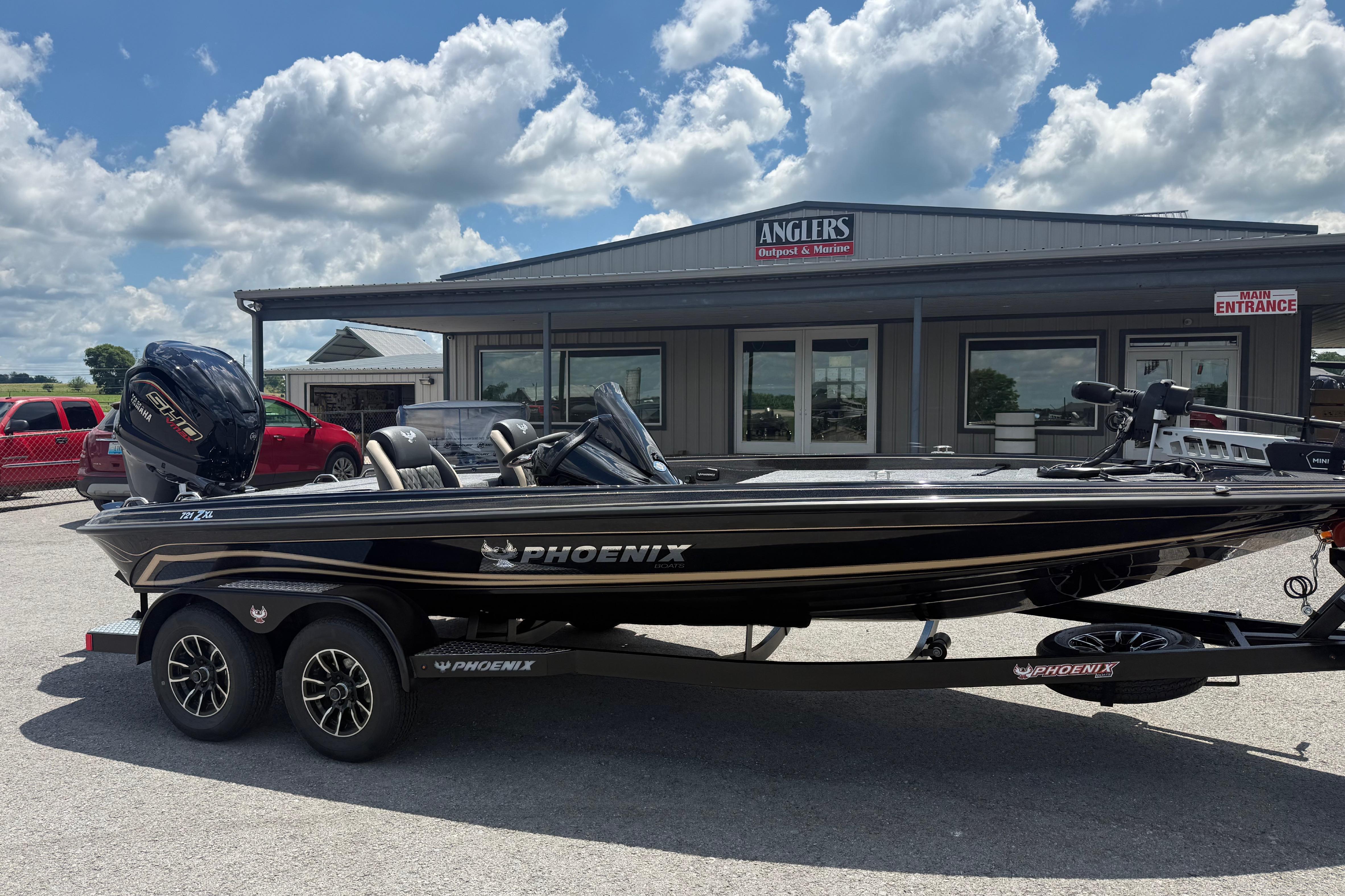 2027 Phoenix 721 ZXL boat parked outside Anglers Outpost & Marine under a cloudy sky.