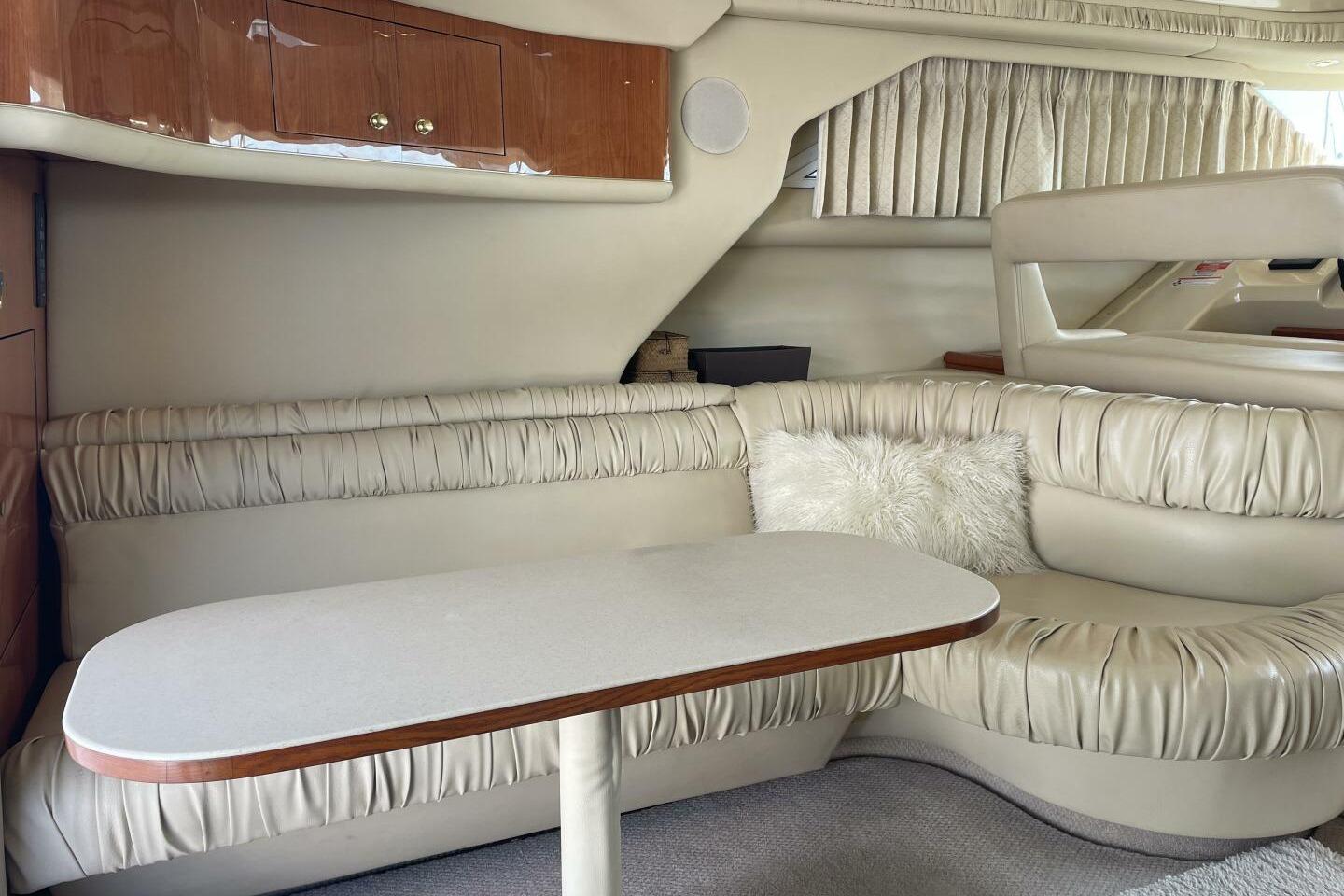 Luxurious interior of 2000 Sea Ray 400 Sedan Bridge with plush seating and table.
