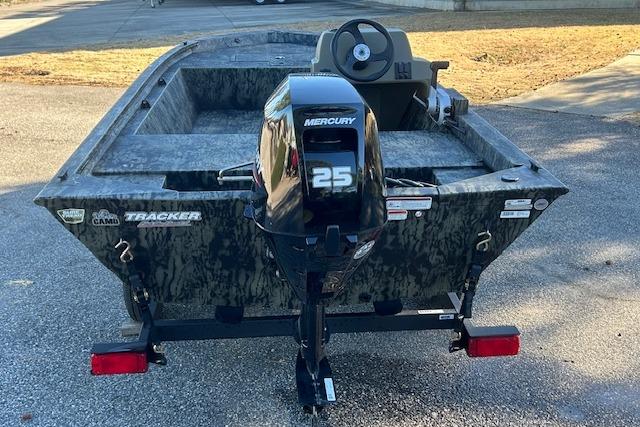 2026 Tracker Grizzly 1648 SC boat with Mercury 25 outboard motor, parked on pavement.