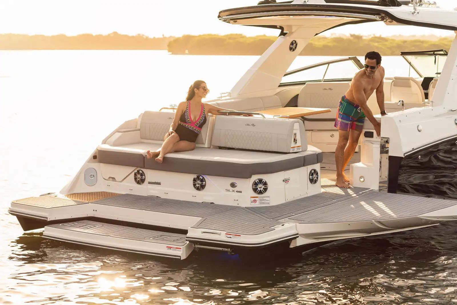 2018 Sea Ray SLX 400 boat with people relaxing on deck at sunset.