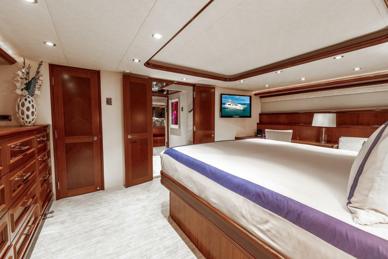 Luxurious bedroom interior on 2012 Westport 112 yacht, featuring elegant wood finishes and modern amenities.