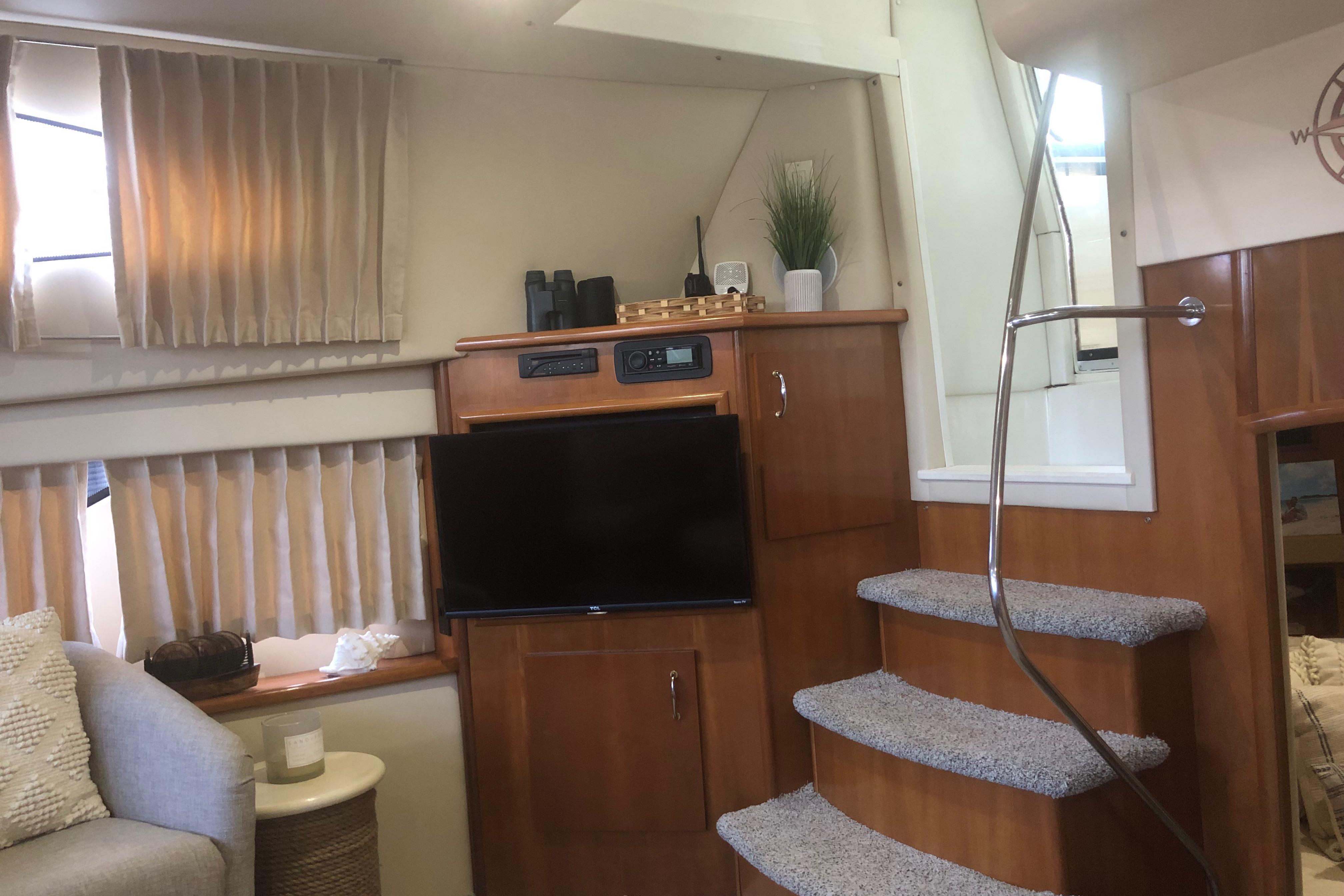 Interior of 2005 Carver 41 Cockpit Motor Yacht with TV, stairs, and cozy seating area.