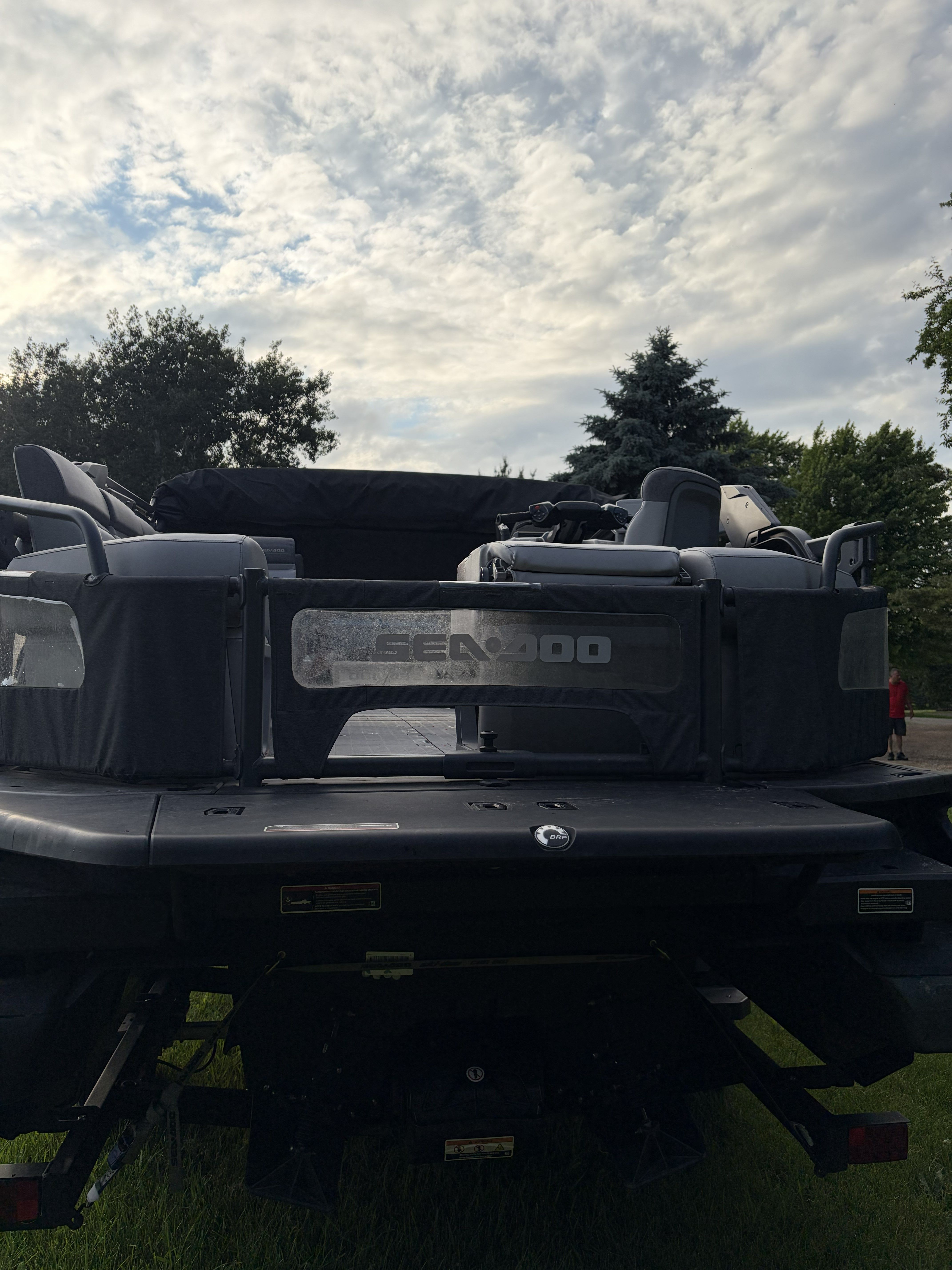 The image shows the rear of a Sea Doo Switch boat on a grassy area.