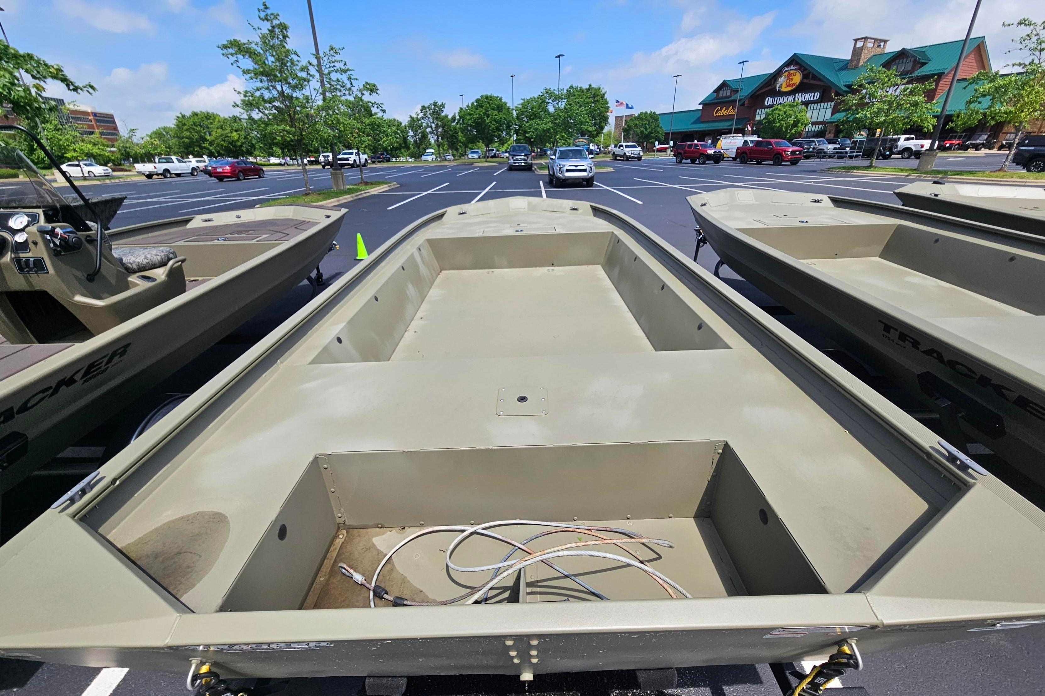 2025 Tracker Grizzly 1860 Utility boat displayed in a parking lot.