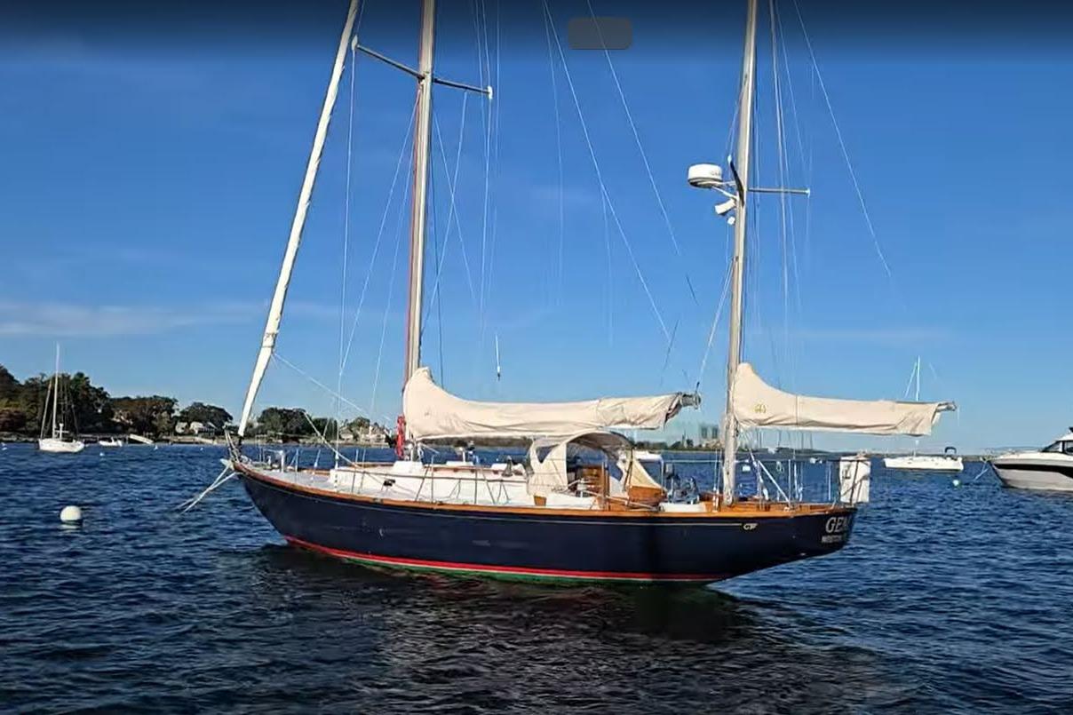 1970 Hinckley Bermuda 40 sailboat anchored on calm water under clear blue sky.