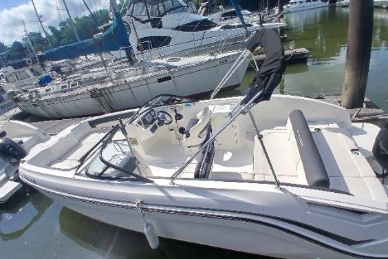 2023 Bayliner DX 2200 boat docked at marina, featuring sleek design and spacious seating.
