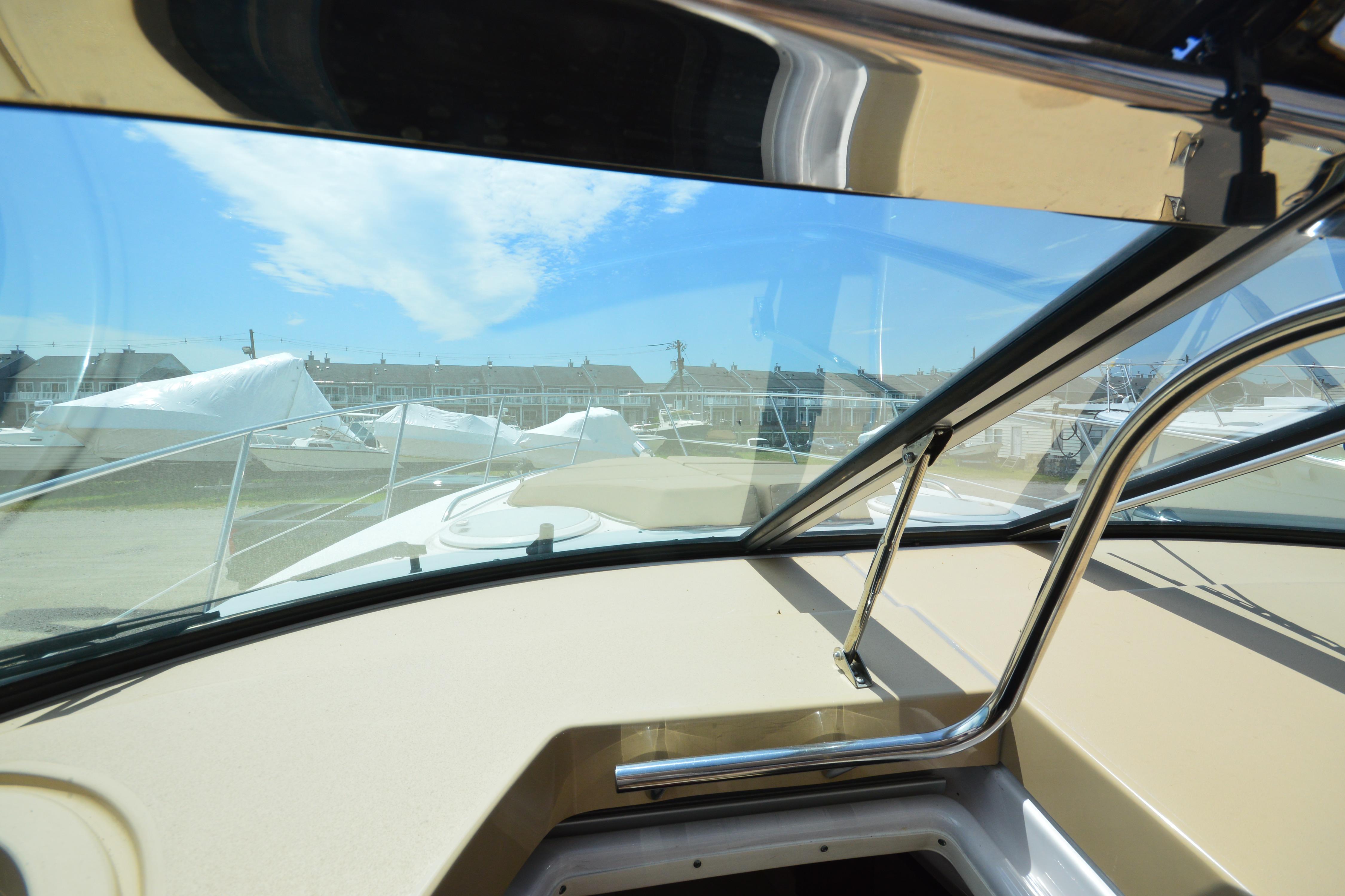 Interior view of 2013 Four Winns V375 boat, showcasing windshield and marina background.