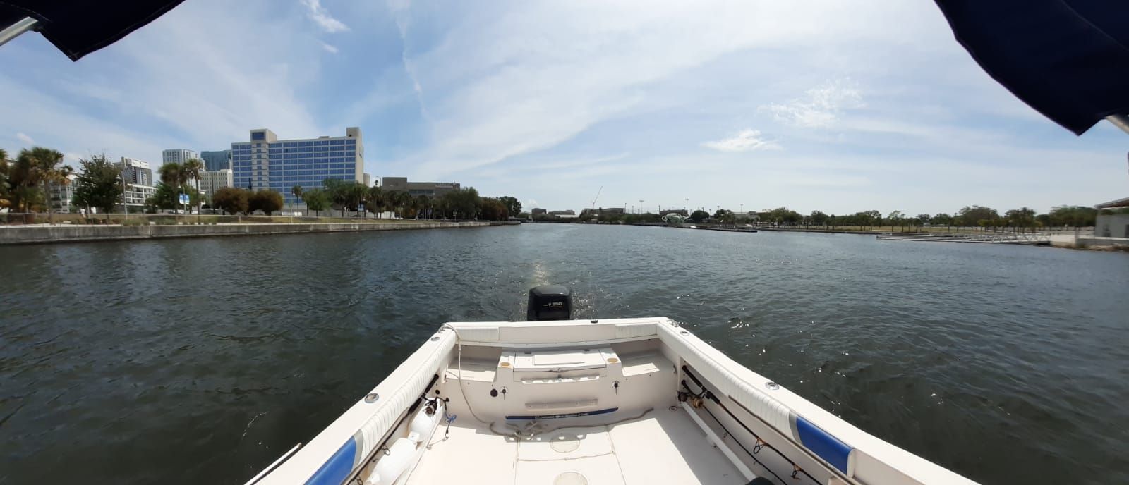 The boat is a 1995 Grady-White Explorer 24, on a calm river with a city view.