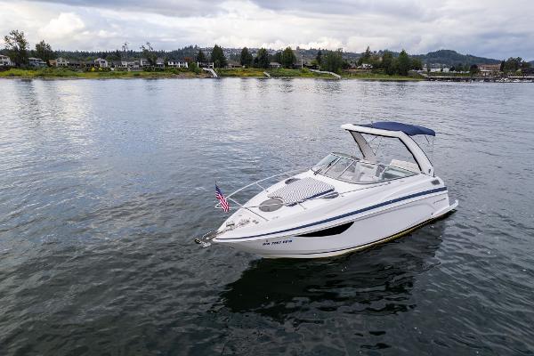 2016 Regal 28 Express boat on calm water with scenic shoreline background.