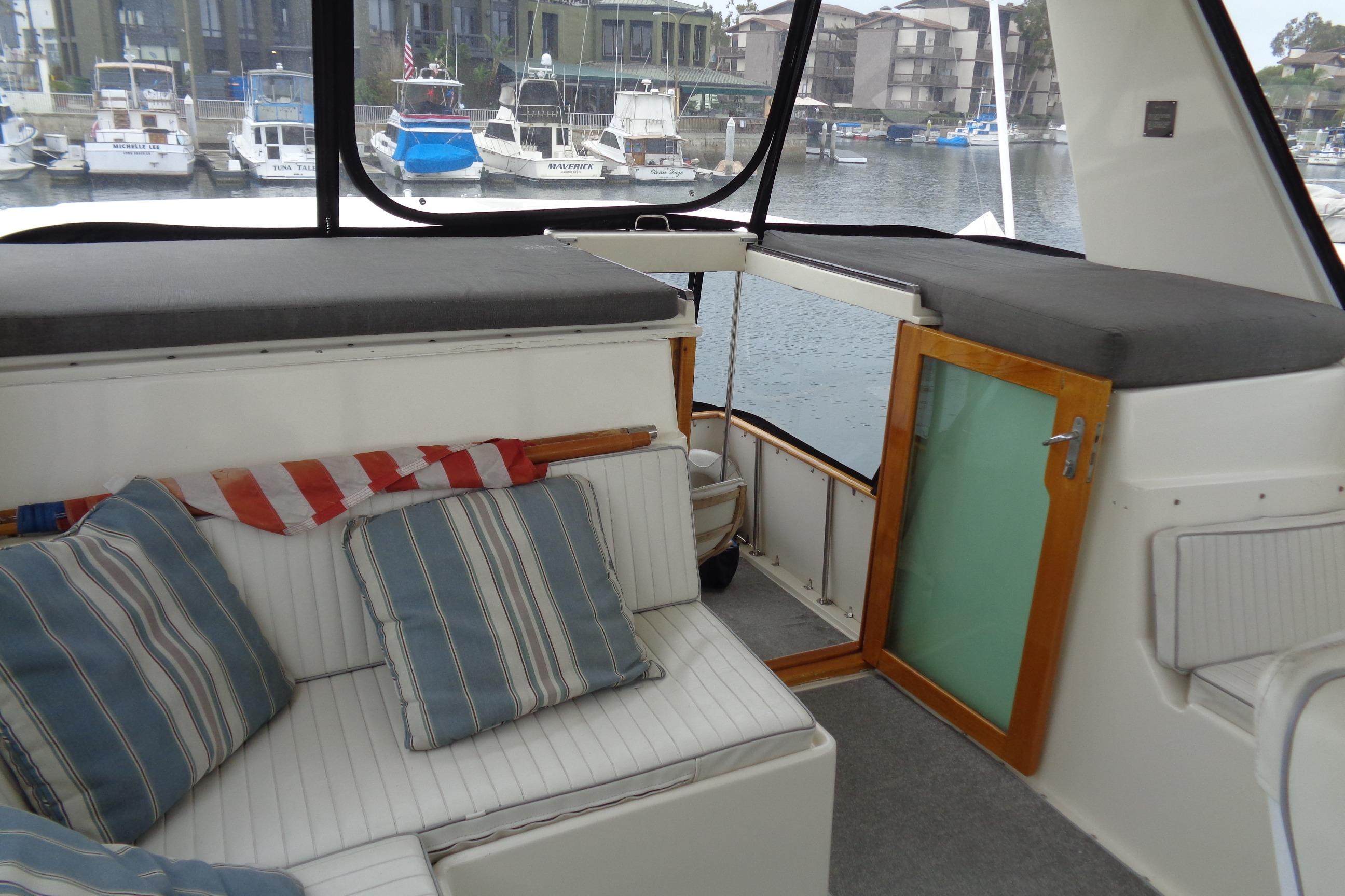 Interior of 1981 Hatteras 48 Cockpit Motor Yacht with striped cushions and marina view.