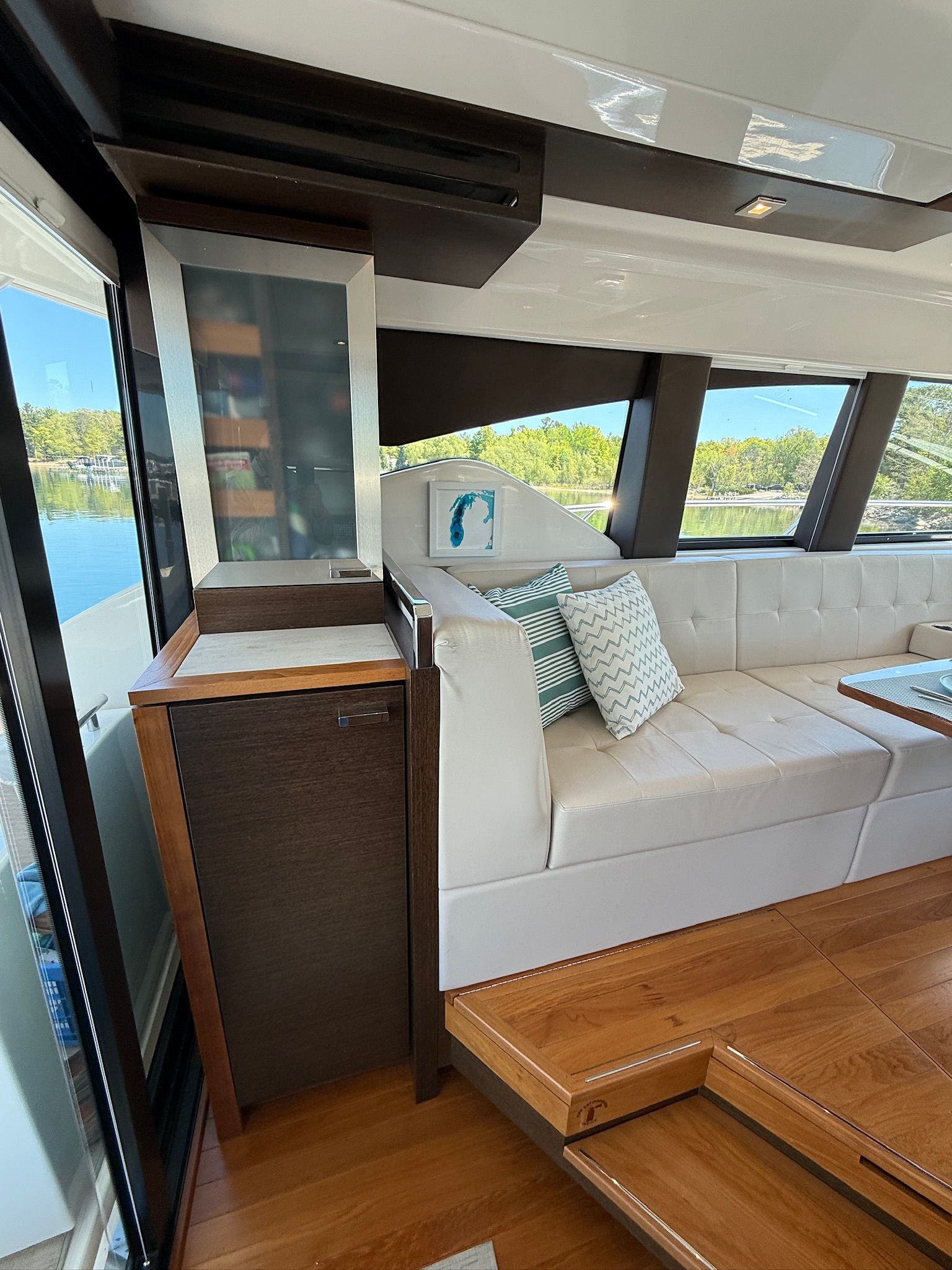 Interior of a 2017 Tiara Yachts C44 Coupe with elegant white upholstery and wooden flooring.