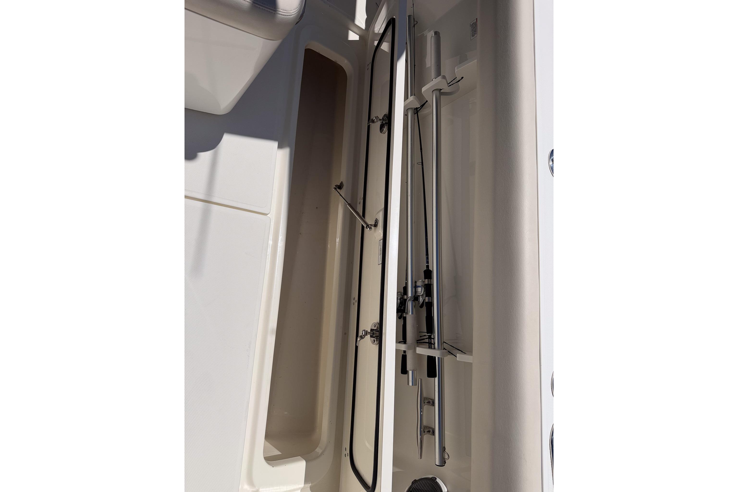 Storage compartment on a 2021 Boston Whaler 330 Outrage boat, showcasing fishing rod holders.