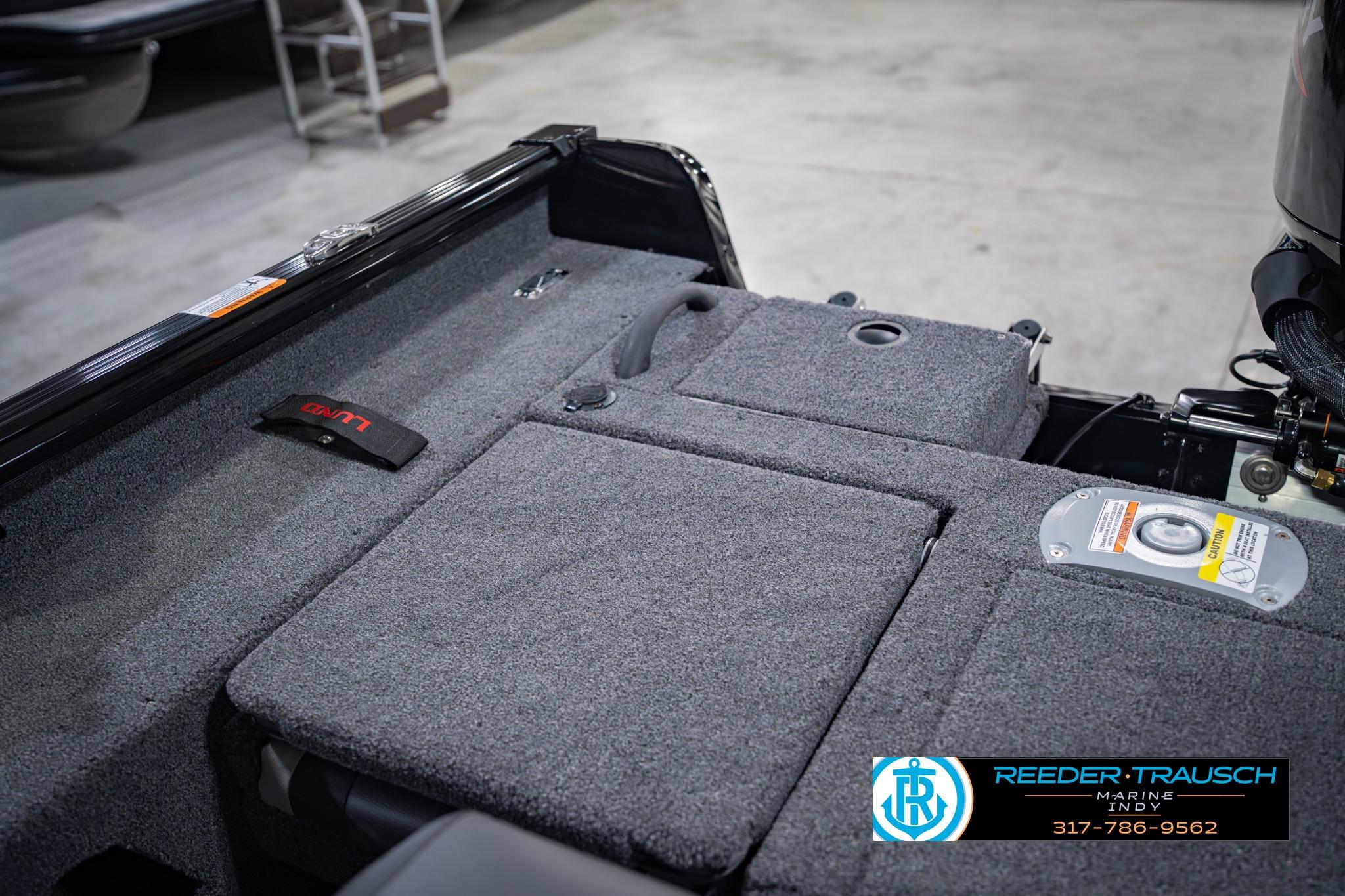 2026 Lund 1775 Impact XS boat interior with carpeted deck and storage compartments.
