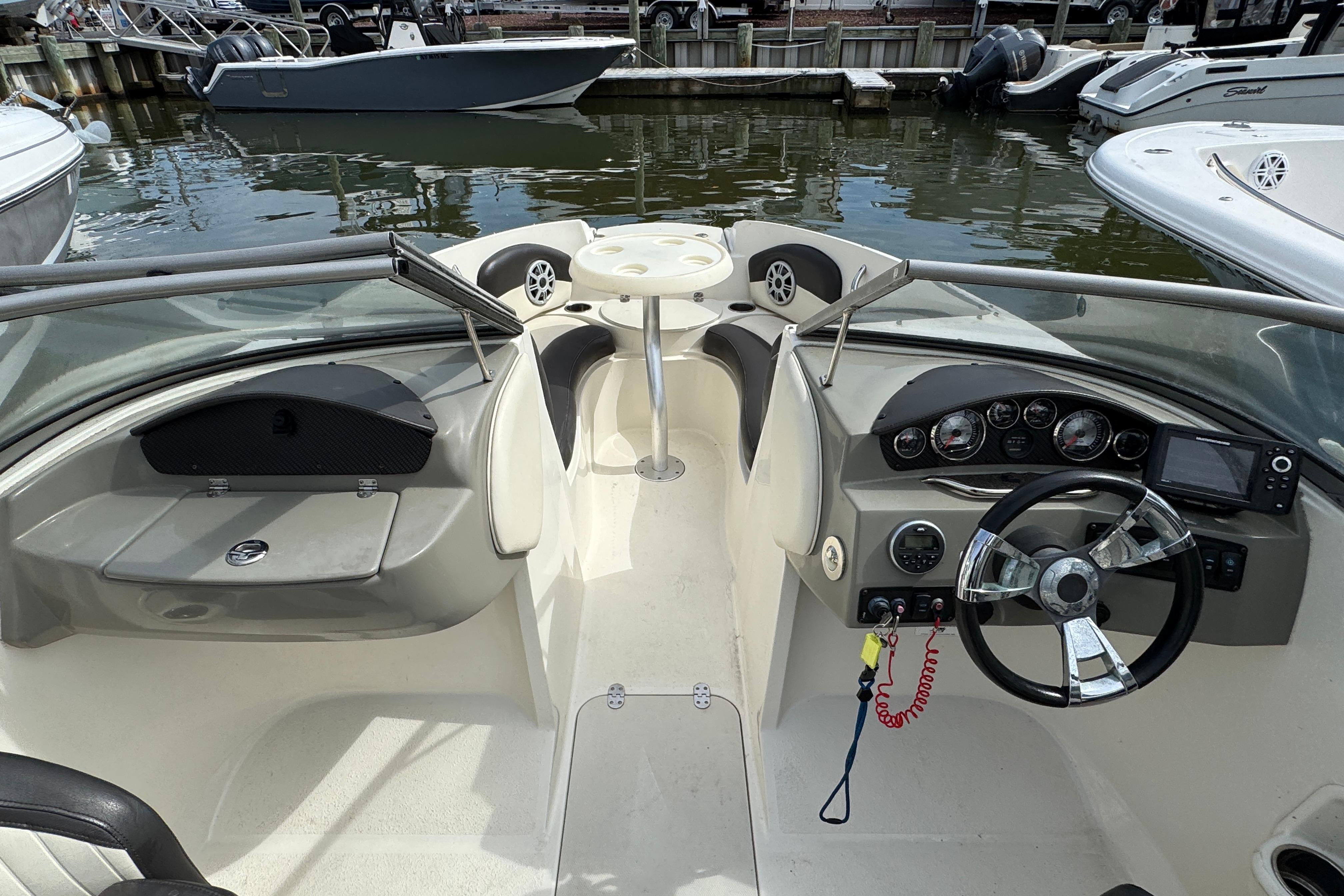 2018 Stingray 204 LR boat interior with steering wheel, dashboard, and seating area.