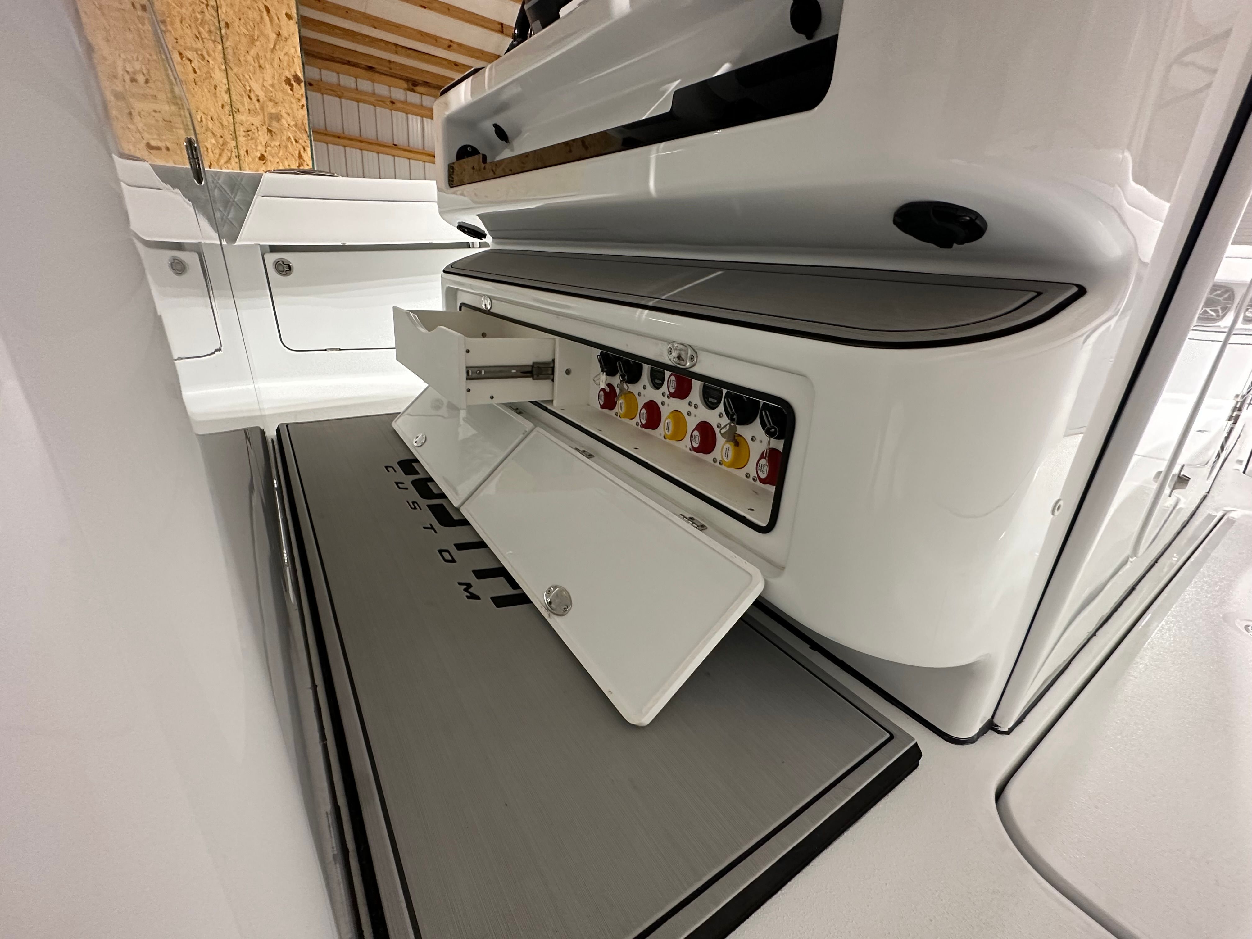 A boat with an open control panel in a storage facility.