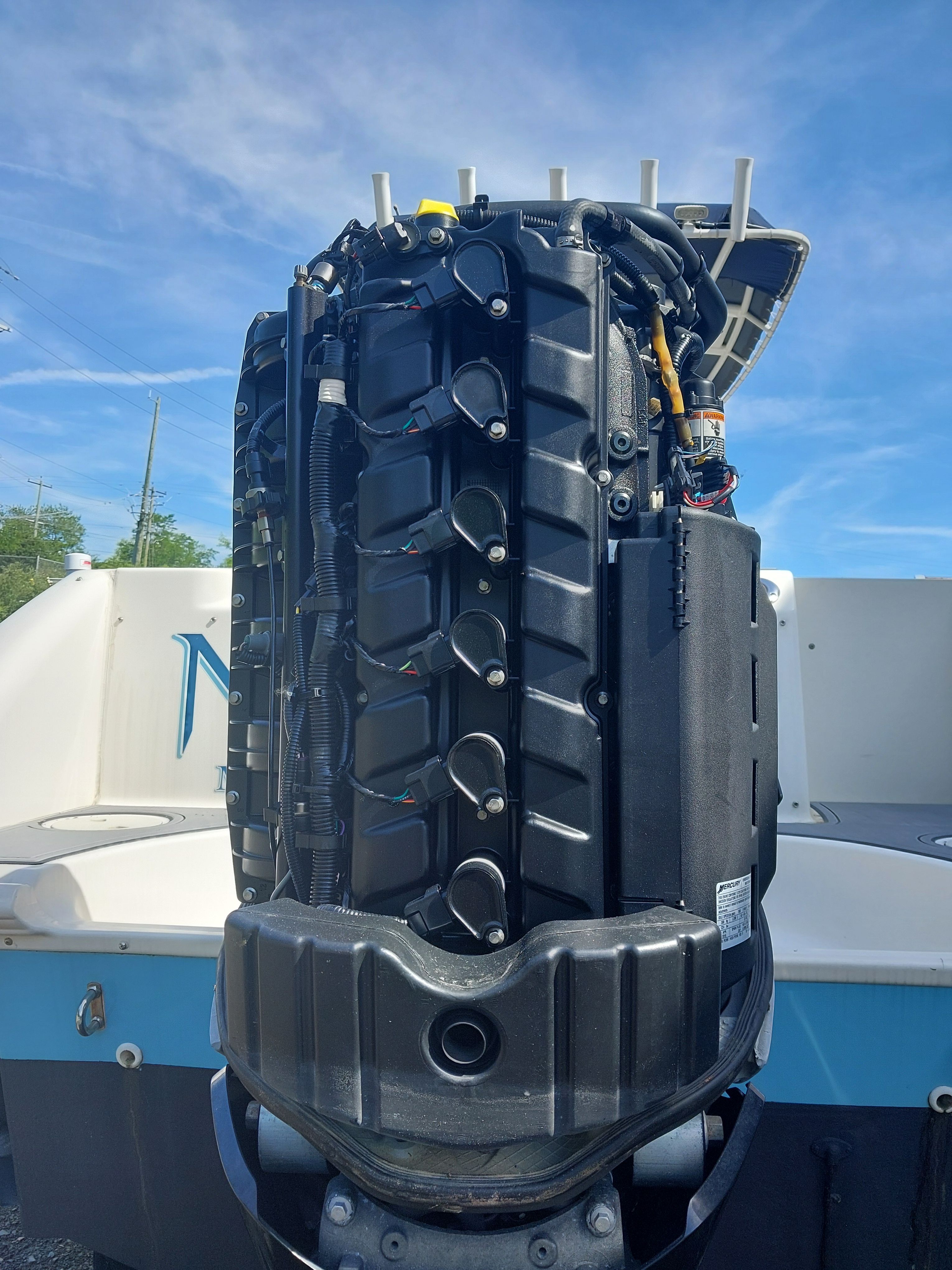An outboard motor of a 2005 Boston Whaler 240 Outrage, with visible cables and components.