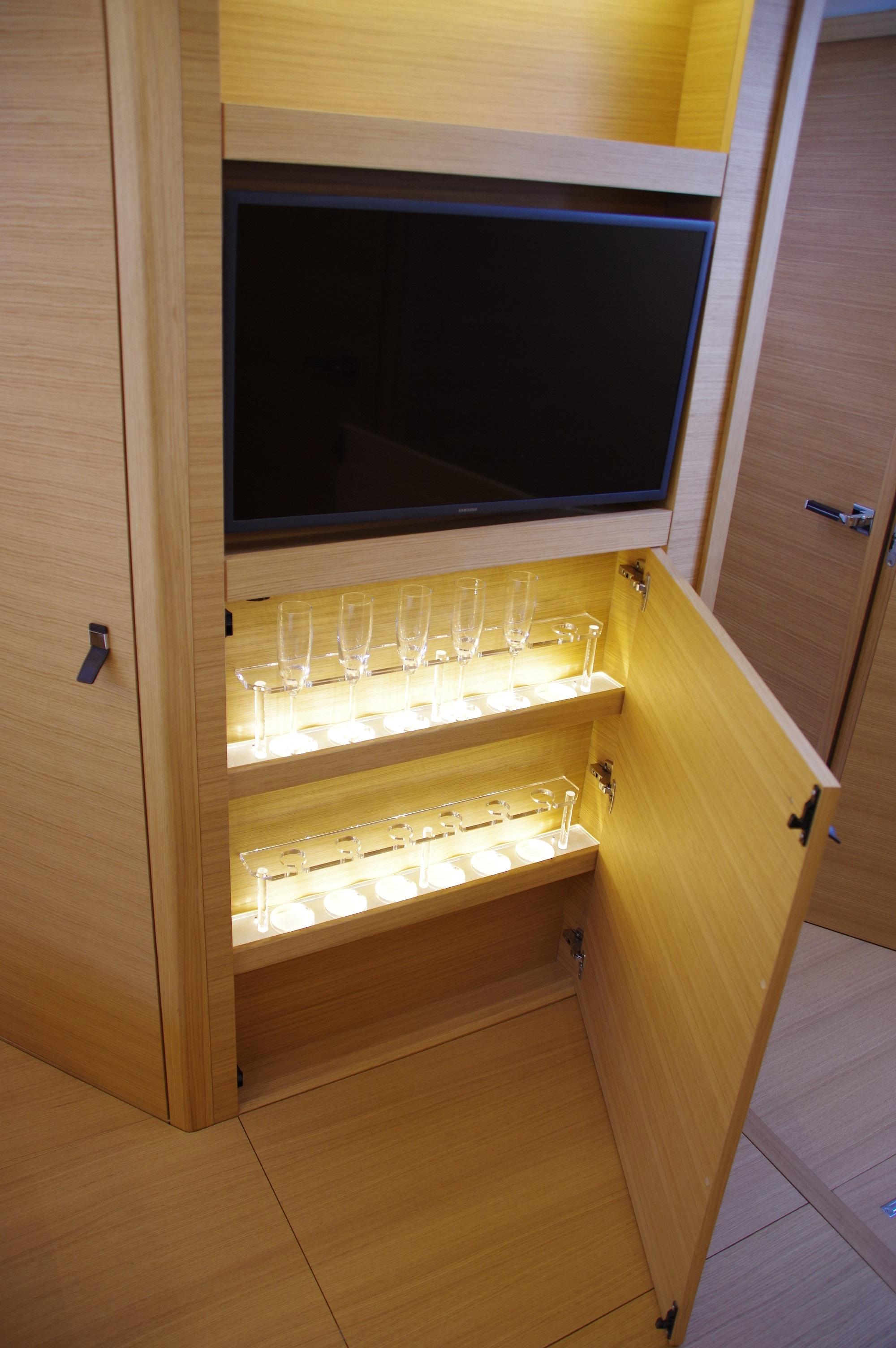 Luxurious interior of 2025 Pardo Yachts 50 with illuminated glass cabinet and TV.