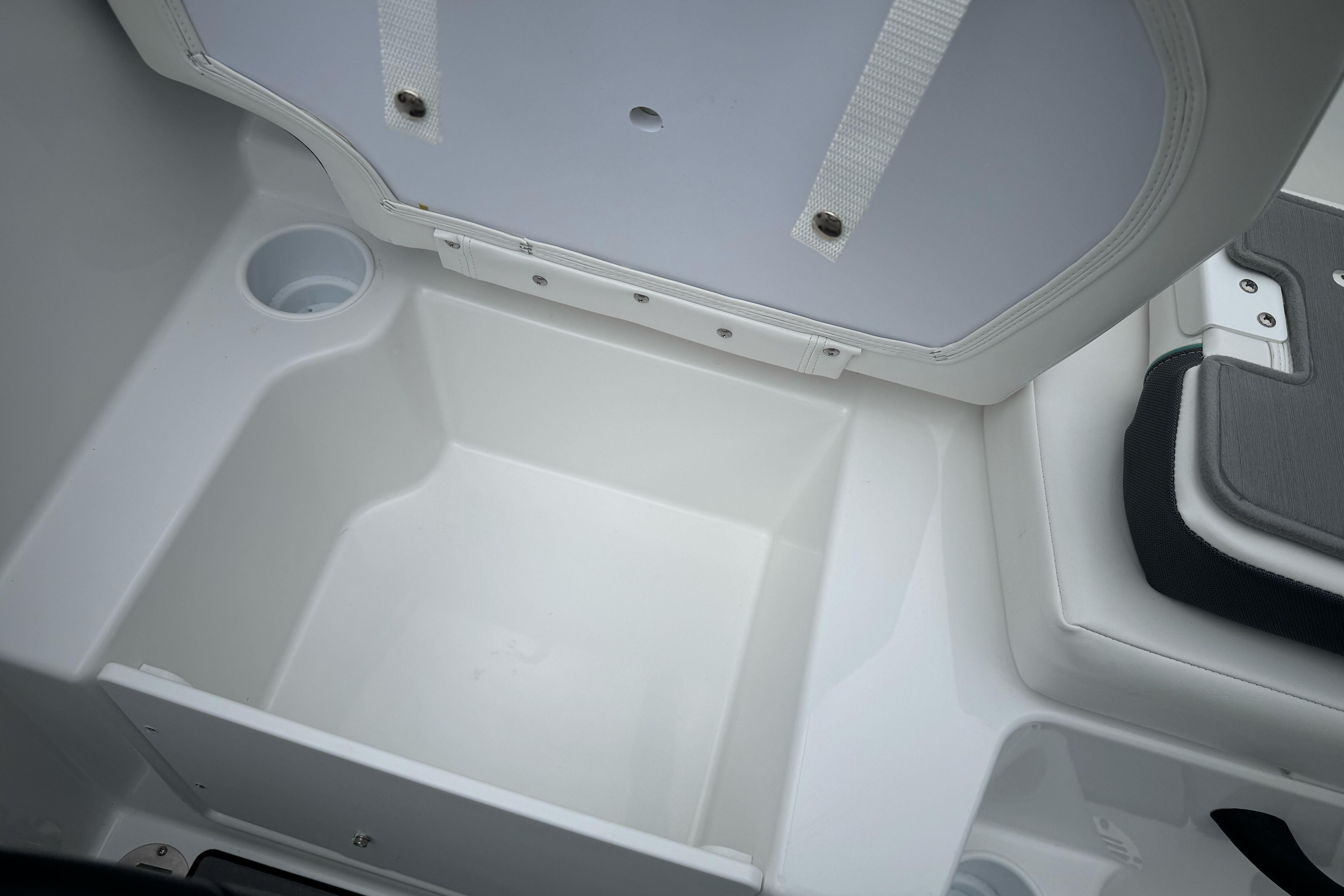 2026 Tahoe T18 boat storage compartment with cup holder, open lid view.