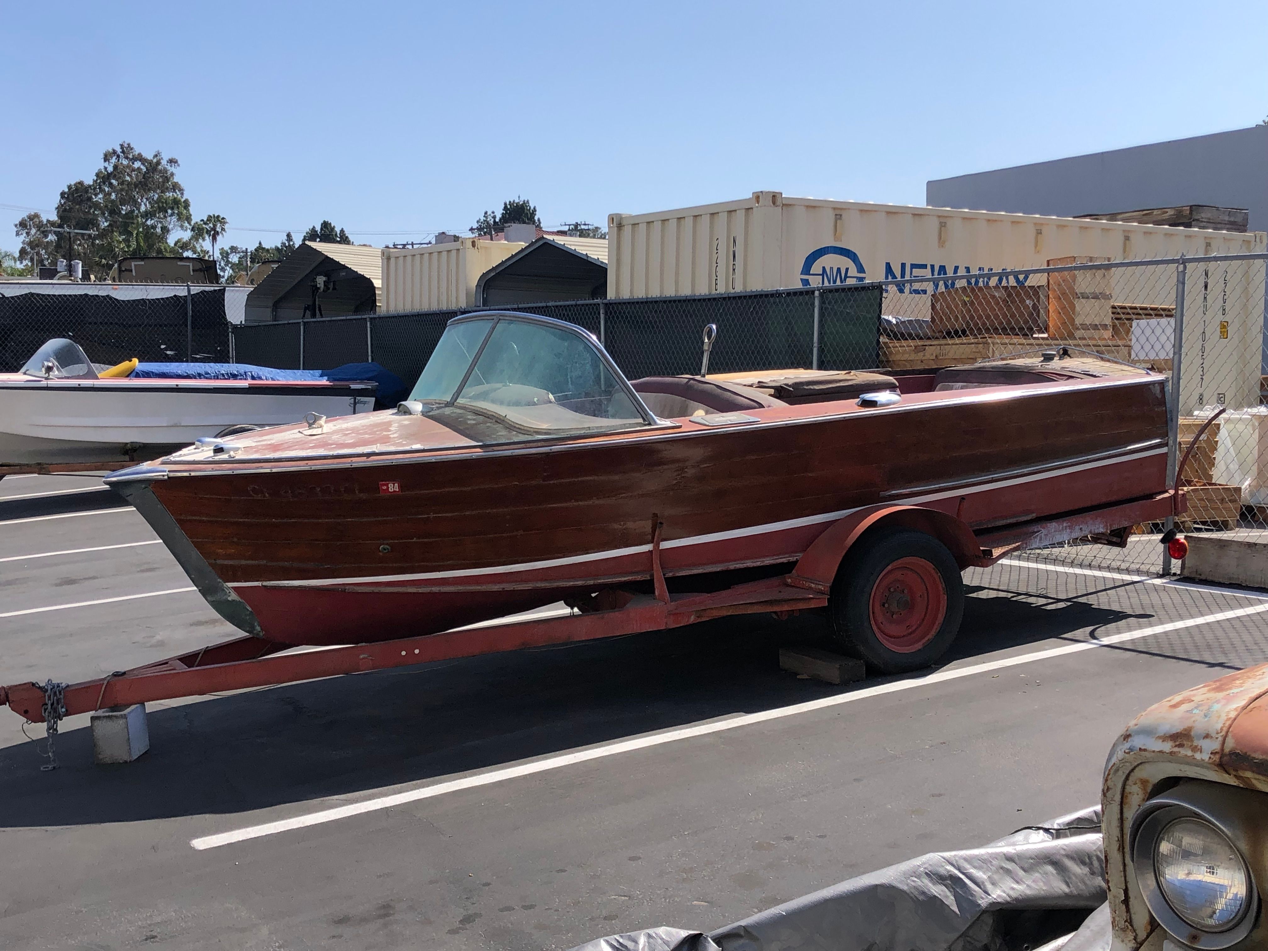 A 1960 Century Resorter on a trailer in a parking lot.