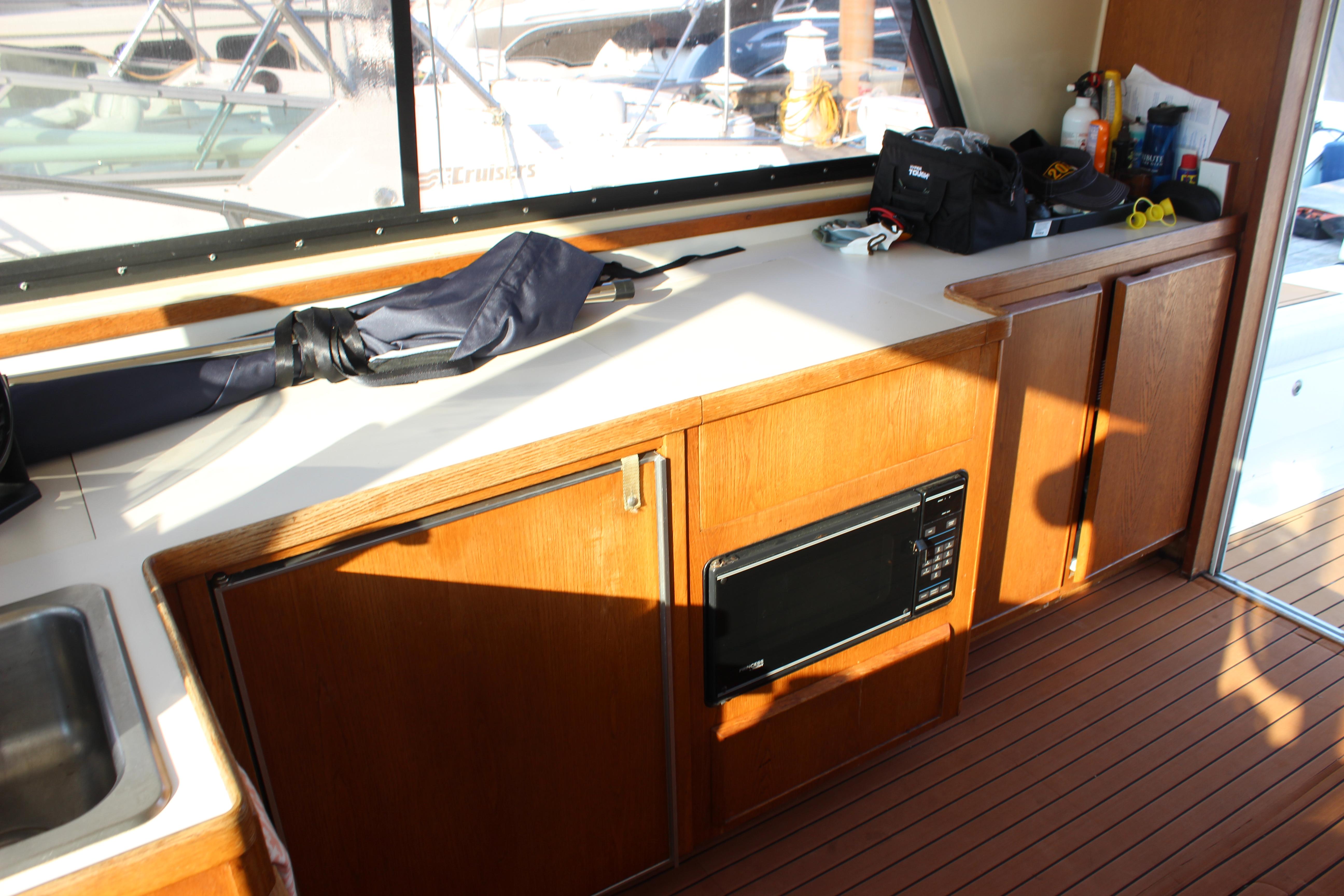 Interior of 1988 Bertram 33II Flybridge Cruiser with wooden cabinets and microwave.
