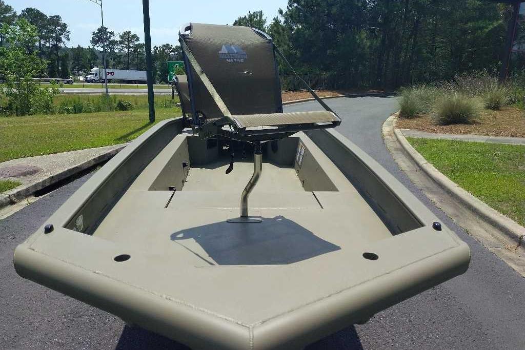 2026 Tracker Grizzly 1650 T Prairie Wings Edition boat on a road, surrounded by greenery.