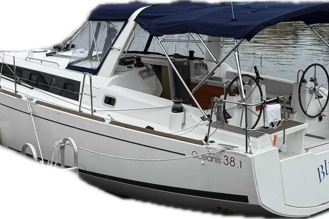 2023 Beneteau Oceanis 38.1 sailboat with blue canopy docked at marina.