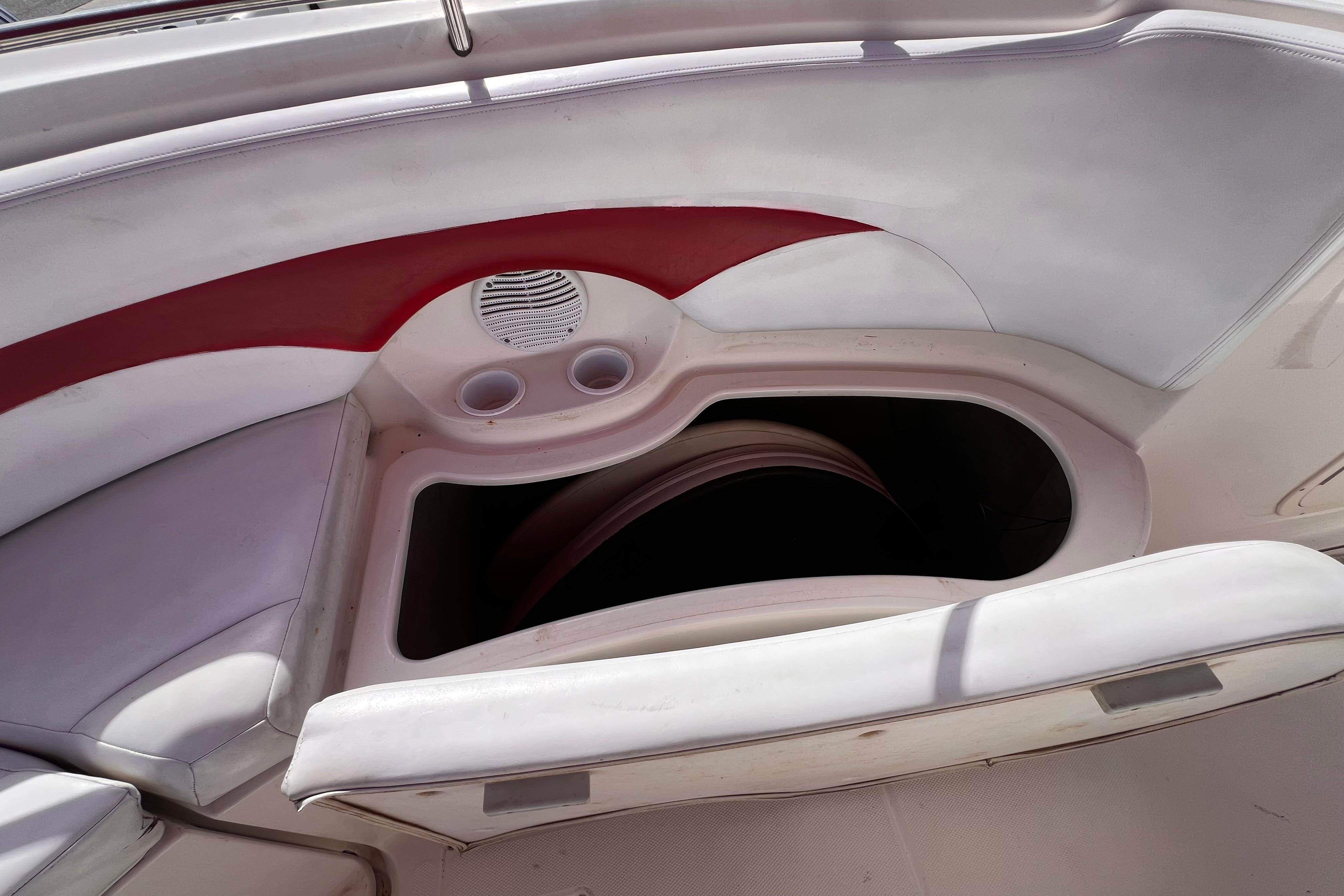 2002 Chaparral 232 Sunesta boat interior with storage compartment and cup holders.