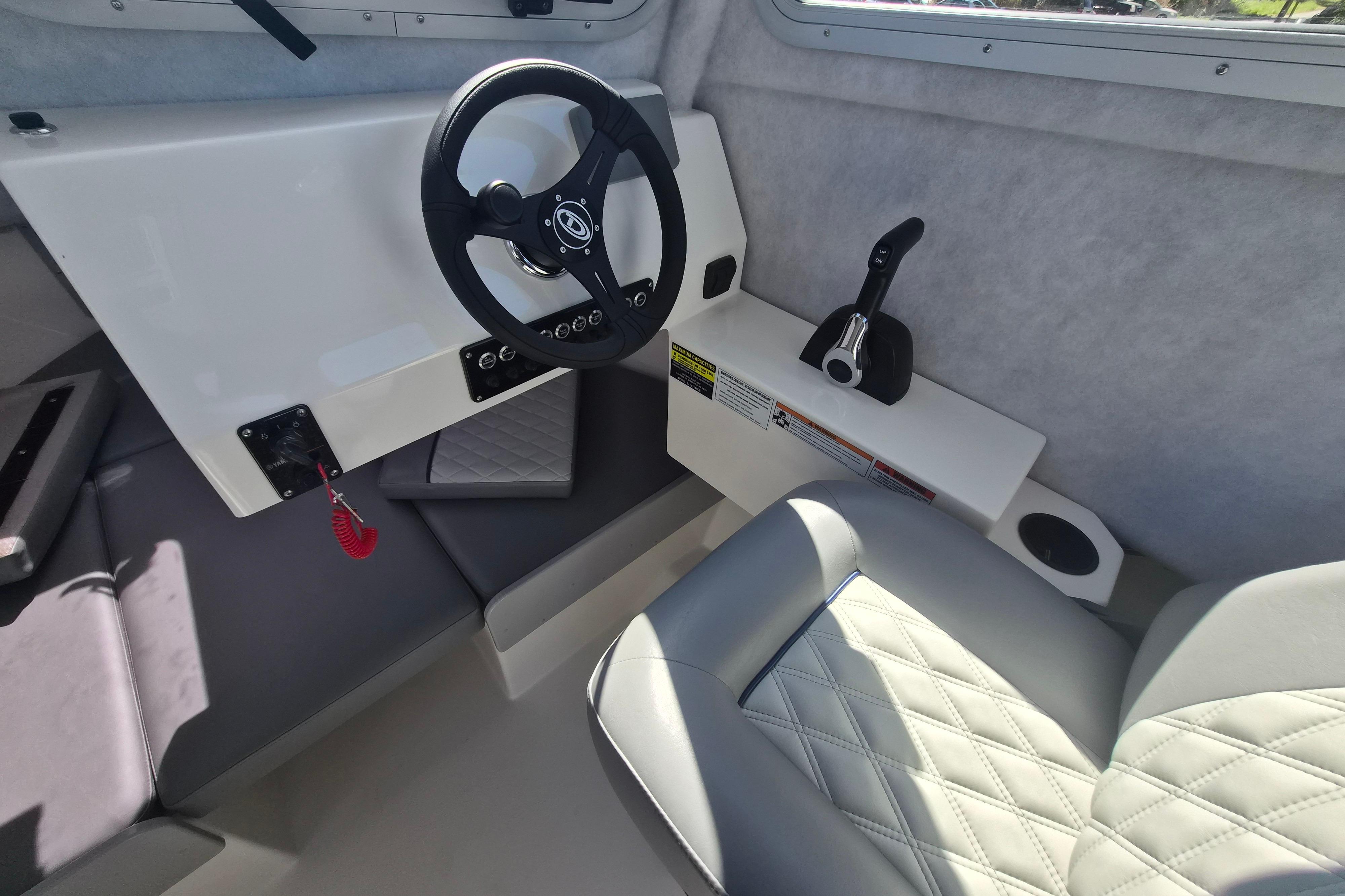 Interior of 2026 Defiance Admiral 220 EX boat, featuring steering wheel and control panel.