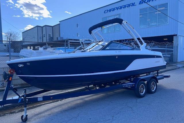 2025 Cobalt CS23 Surf boat on trailer outside Chaparral Boats building.