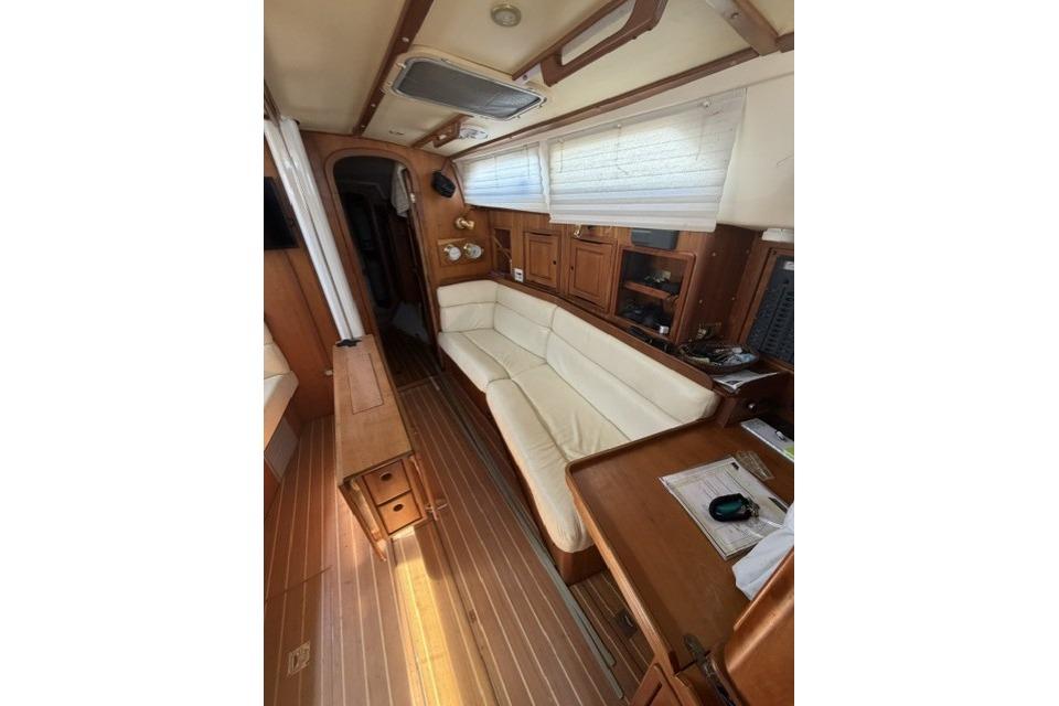 Interior of 2002 Saga 43 sailboat with wooden furnishings and white seating.
