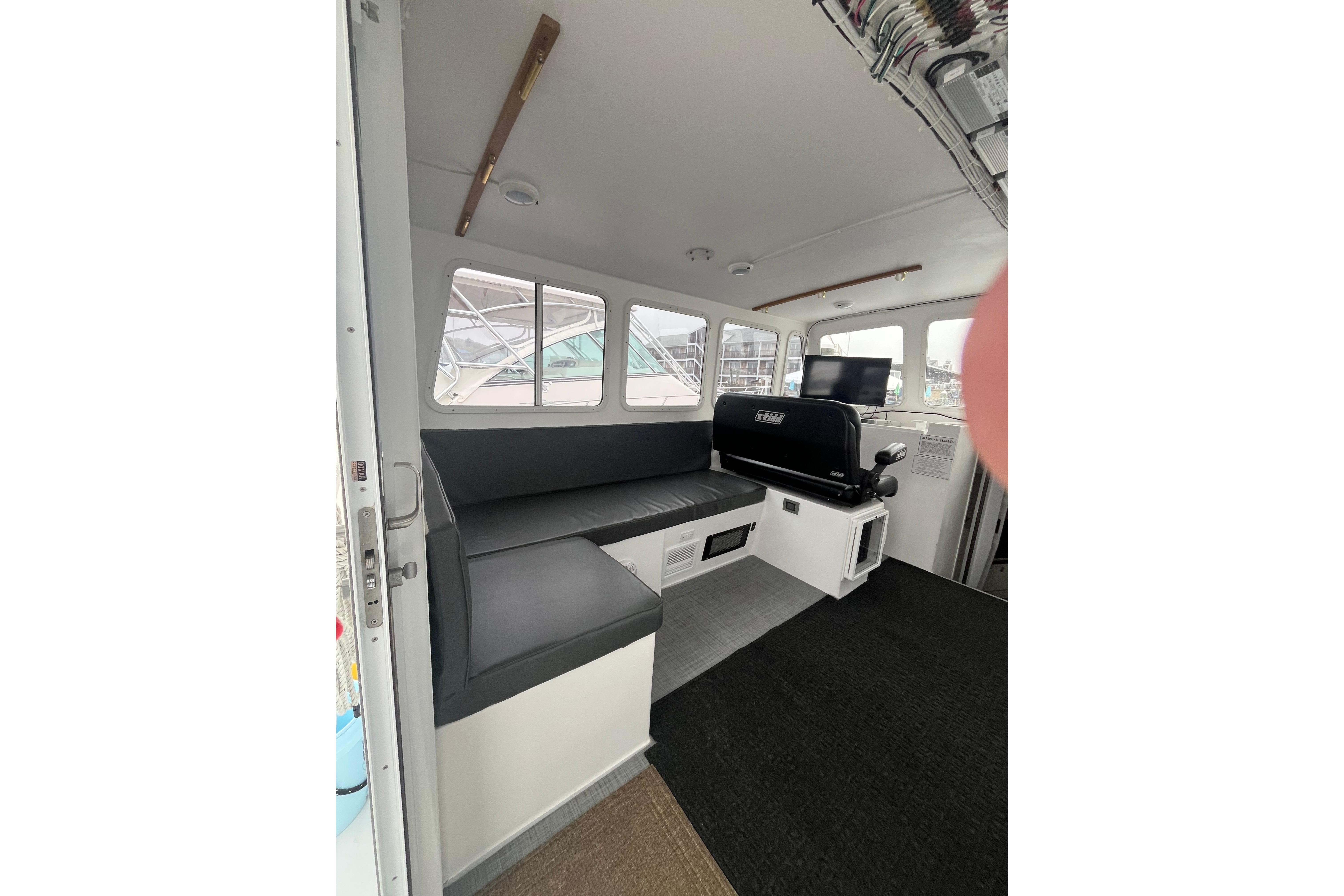 Interior of 2018 H&H Marine Osmond Beal boat with seating and windows.