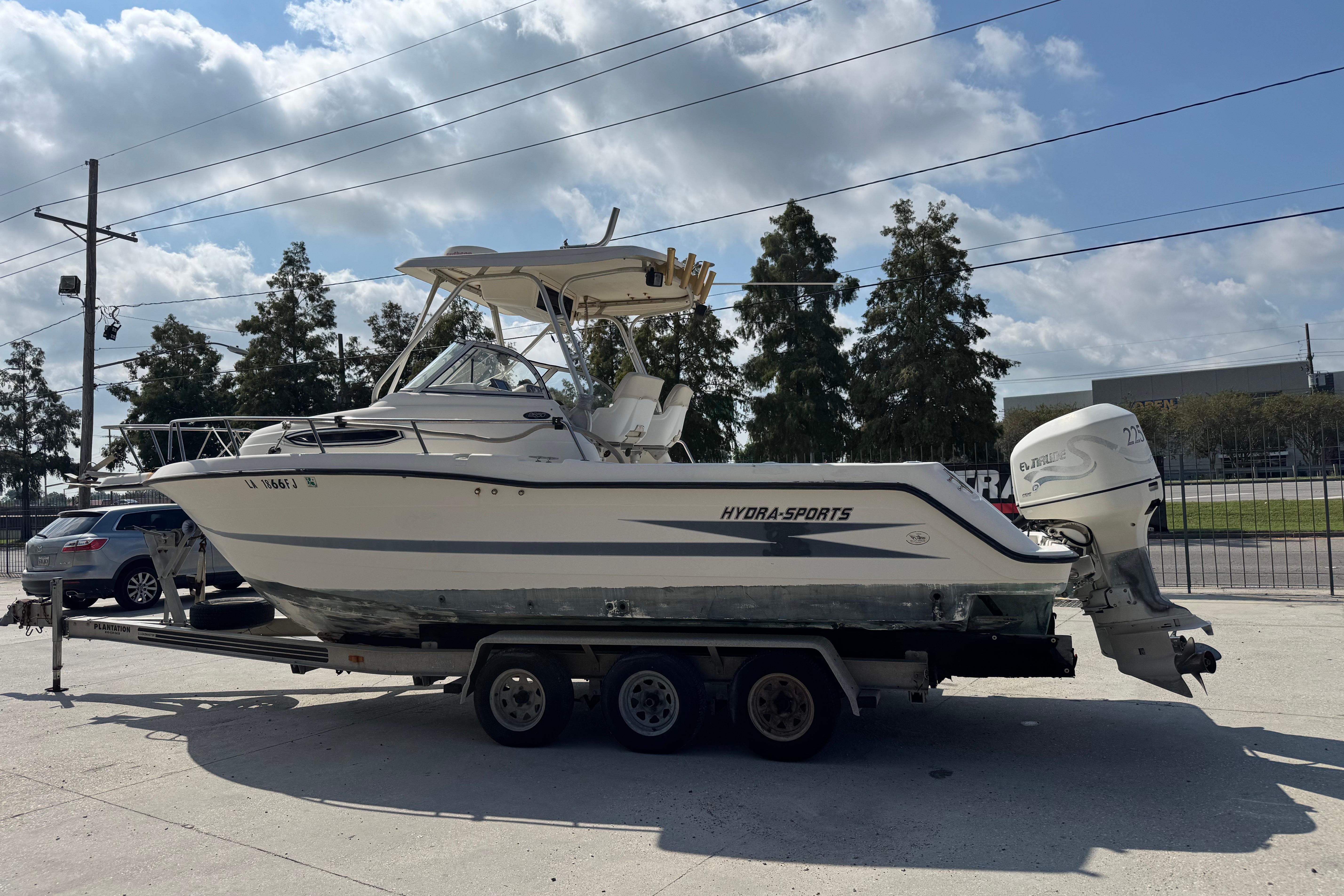 1997 Hydra-Sports VECTOR 2650 WA boat on trailer, parked outdoors under cloudy sky.