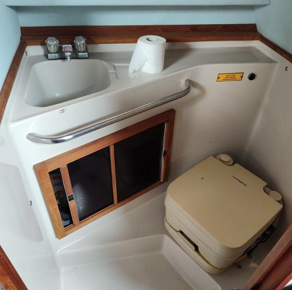 1988 Sea Ray 268 DA boat bathroom with sink, toilet, and storage cabinet.