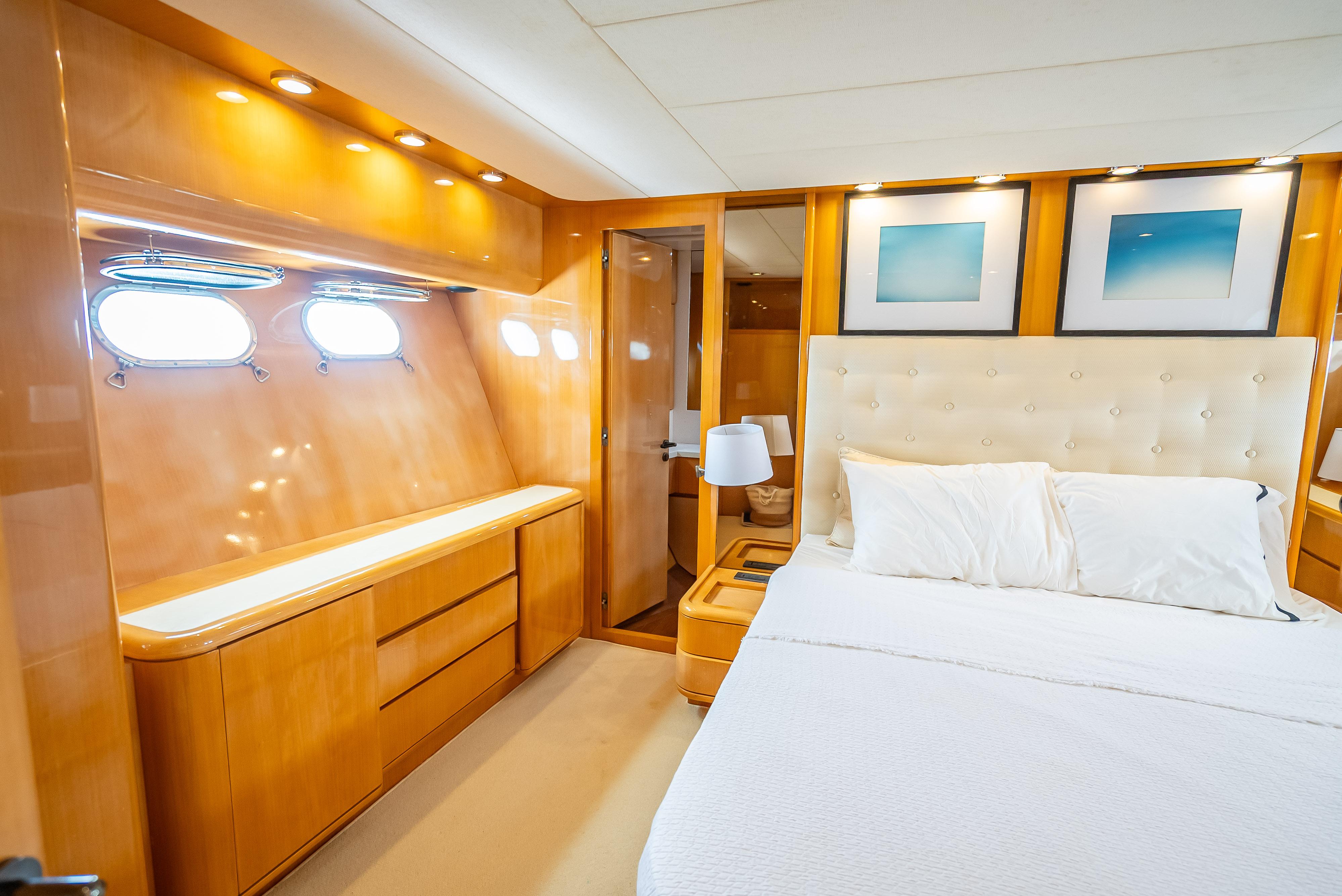 Luxurious bedroom interior of 1995 Sanlorenzo 62 yacht with elegant wood finishes and modern decor.