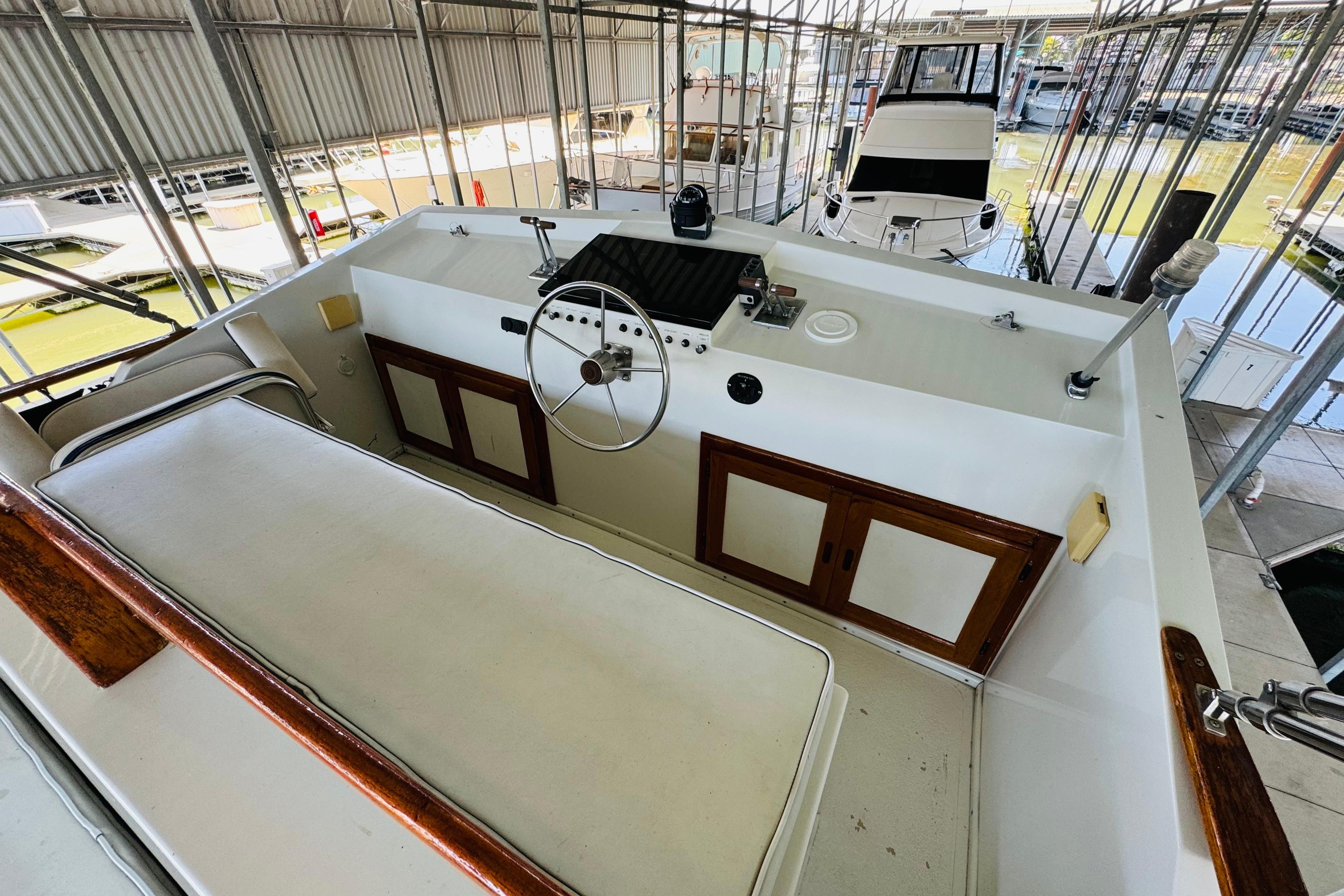 1978 Californian 42 LRC yacht helm with steering wheel and control panel in marina.