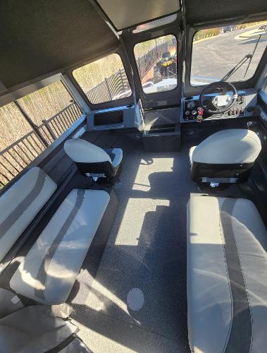 Interior of 2025 Spartan 200 Astoria boat with seating and control panel.