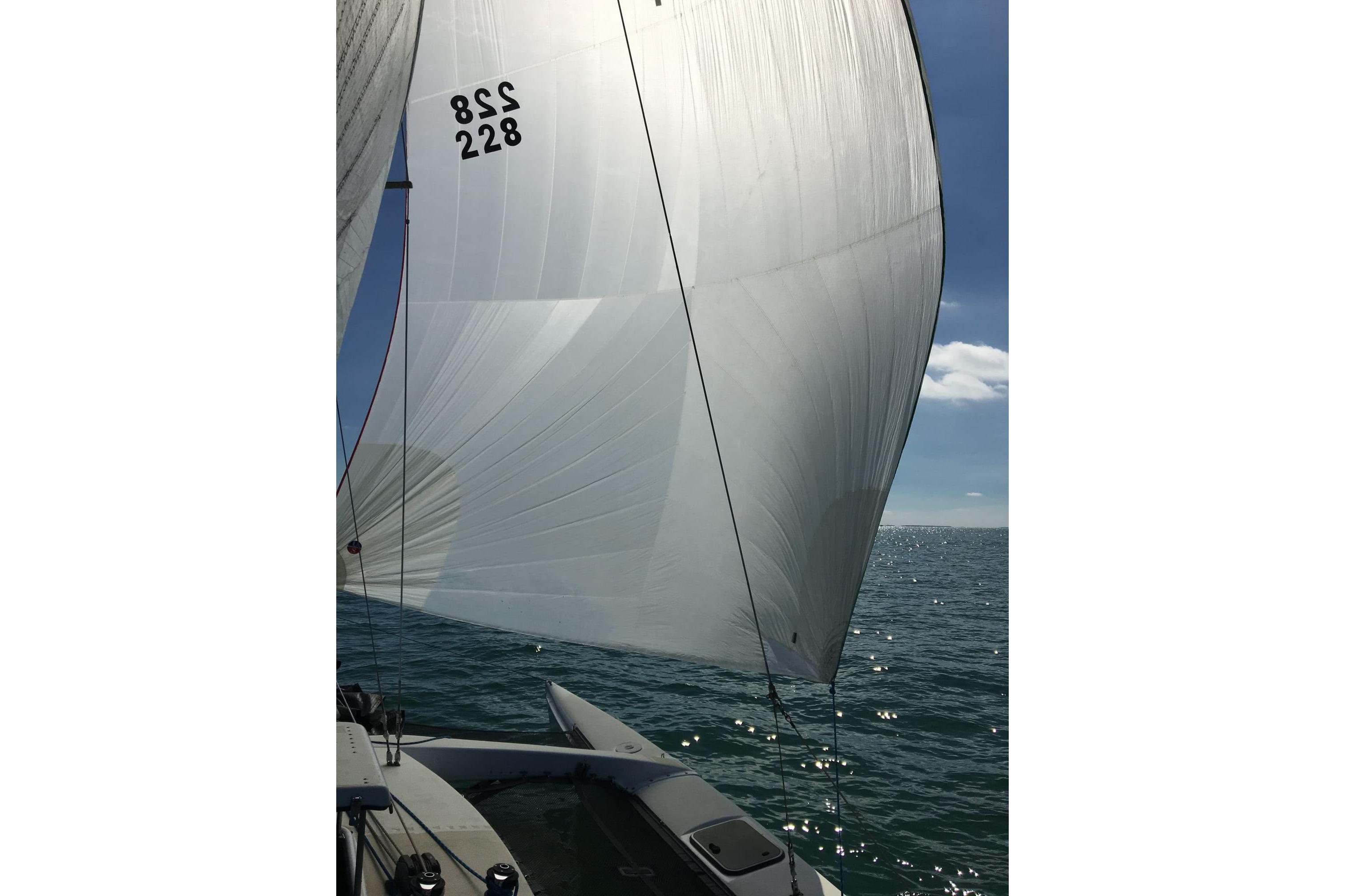 Sailing on a 1991 Corsair F-27 trimaran with full sails on open water.