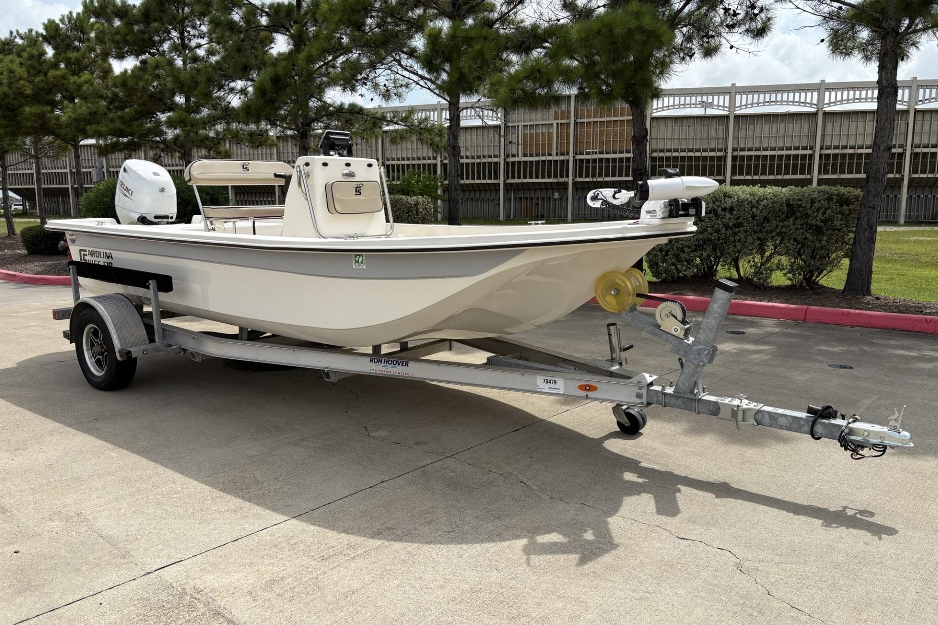 2024 Carolina Skiff E18 JVX CC boat on trailer, parked outdoors.