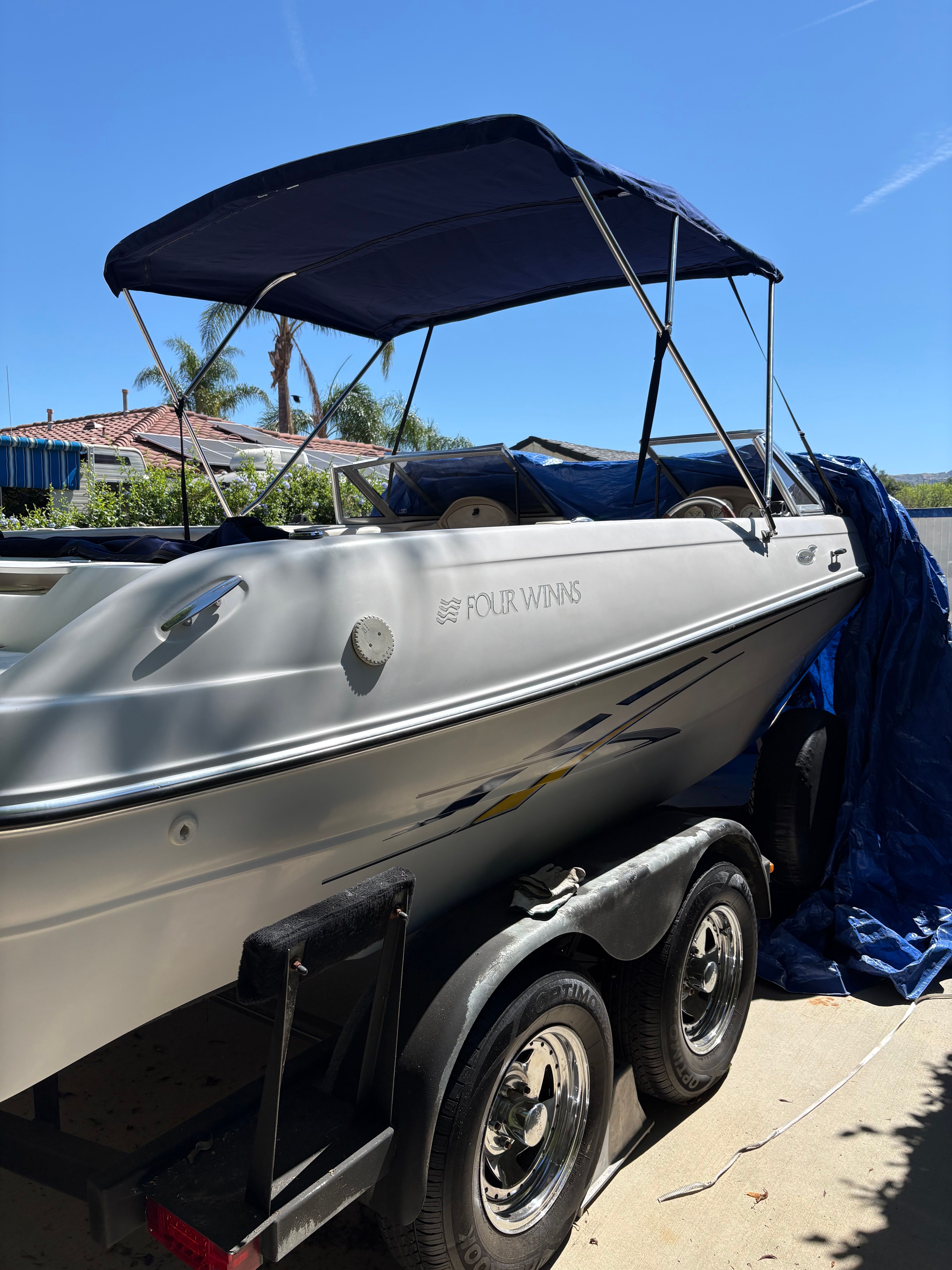 2007 Four Winns 203 Horizon boat on trailer, blue sky.