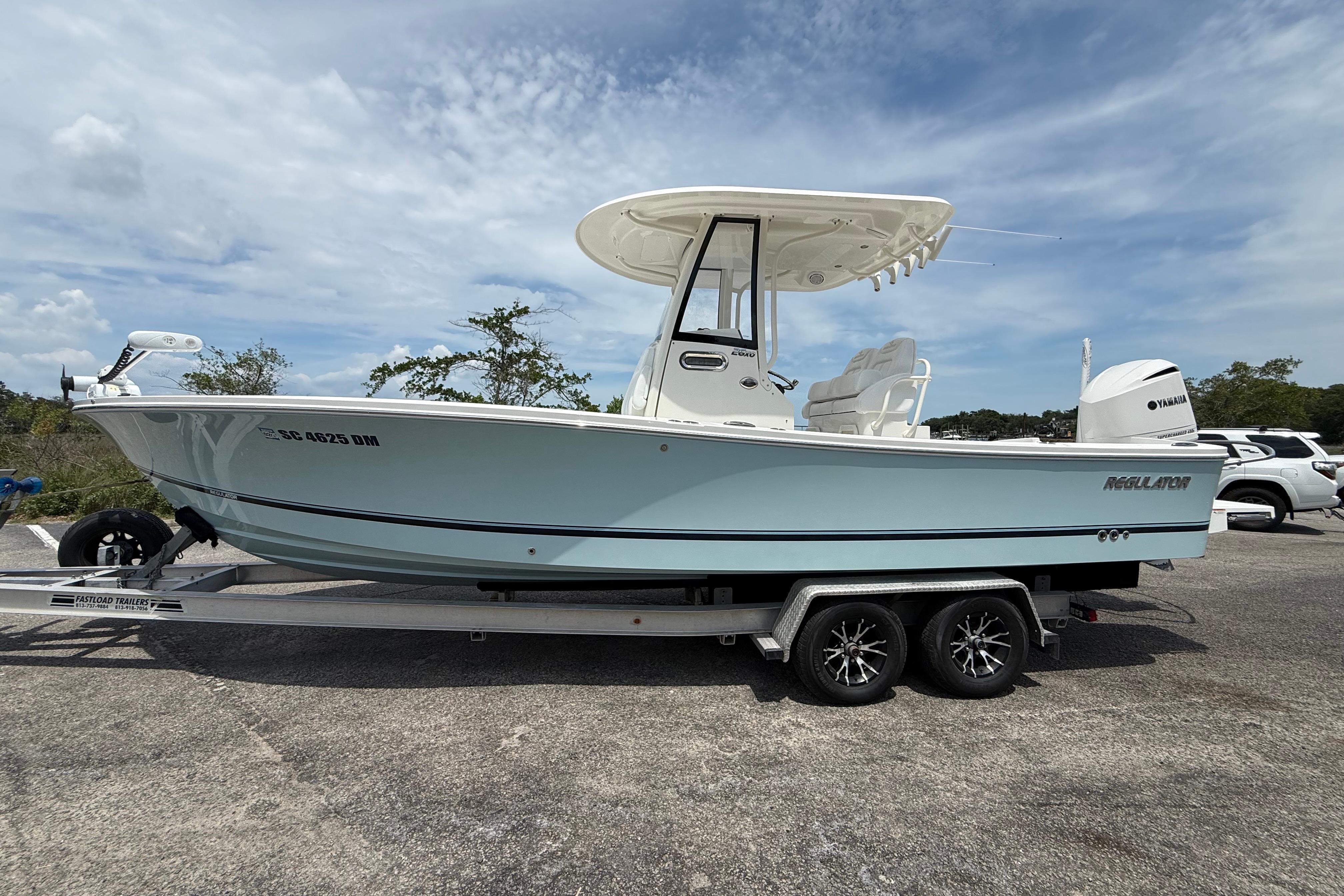 2019 Regulator 26XO boat on trailer, parked outdoors under a cloudy sky.