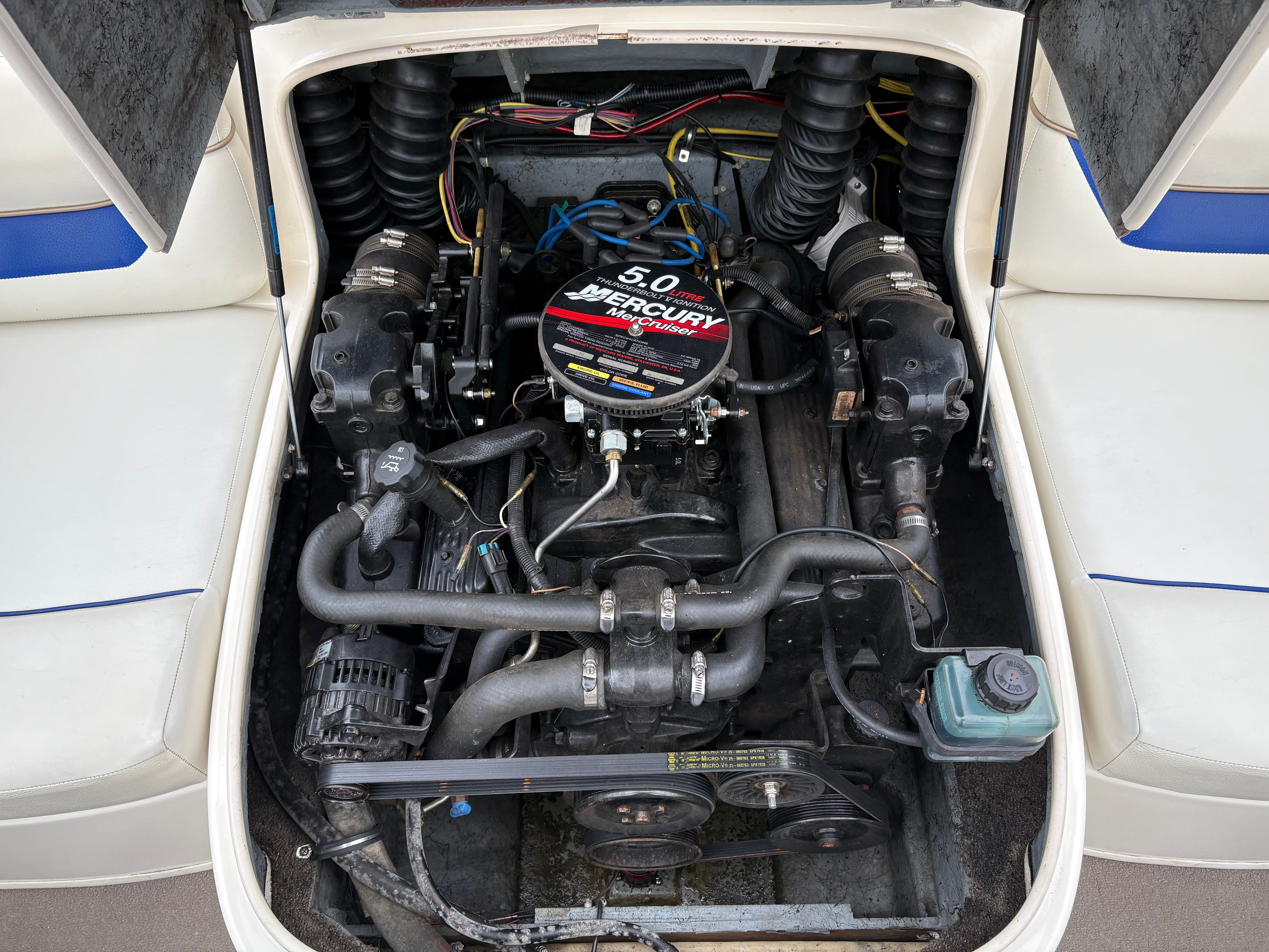 Engine compartment of a 2003 Bayliner CAPRI 205 boat, featuring a 5.0 Mercury engine.