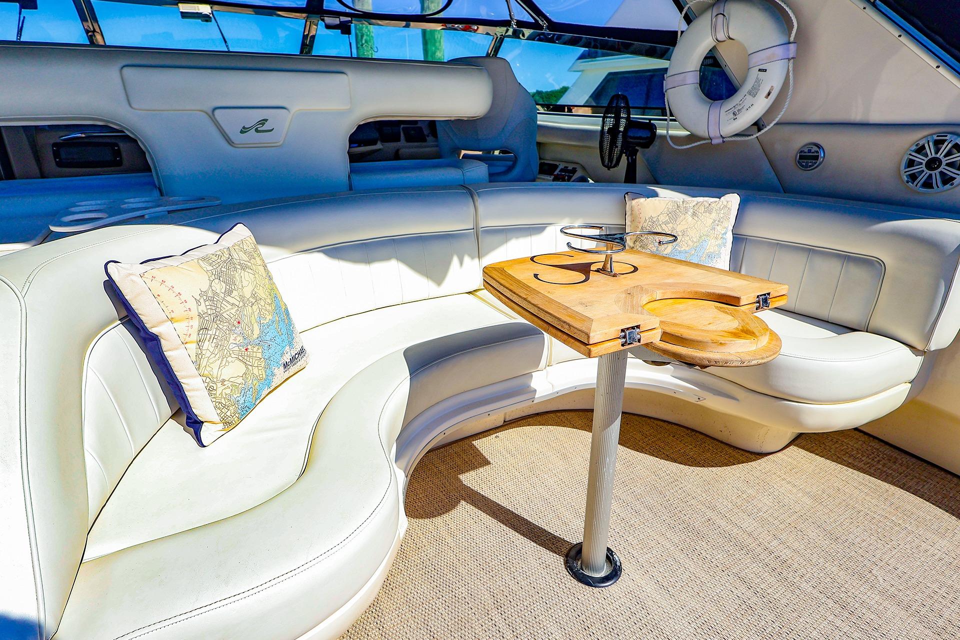 Luxurious interior of 1998 Sea Ray 500 Sundancer yacht with plush seating and wooden table.