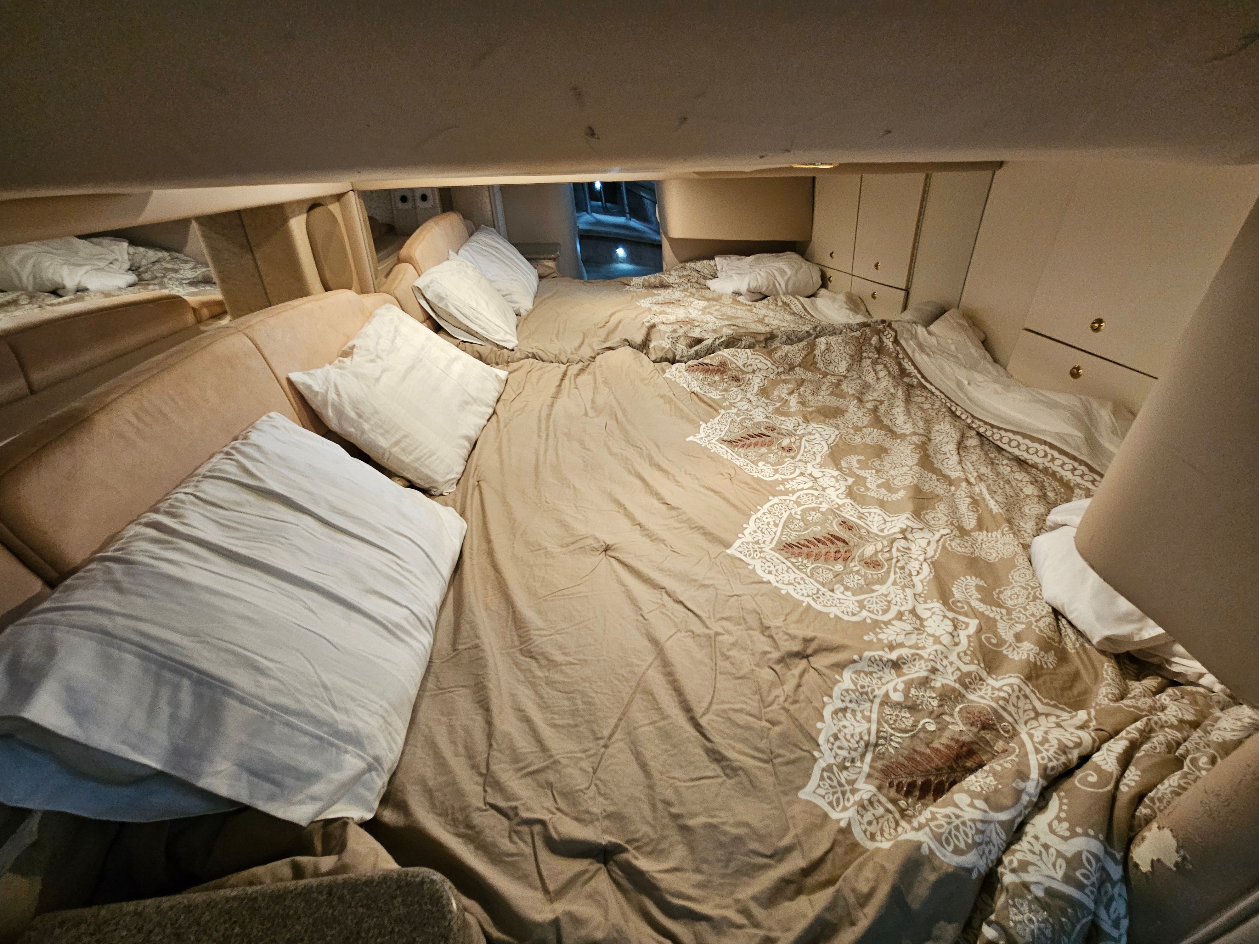 The image shows a cozy cabin with a large bed and several pillows.